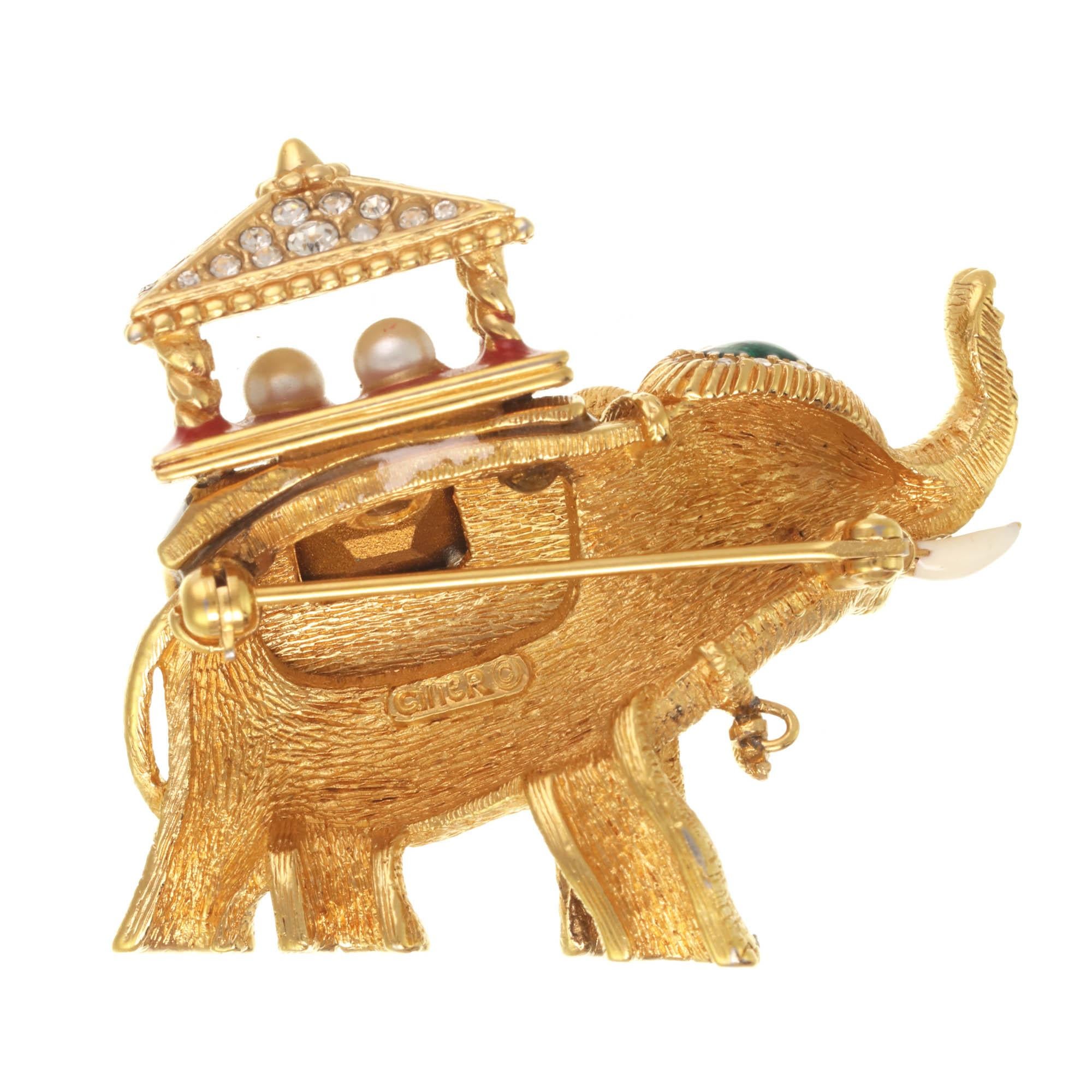 Trunks up! This gorgeous lucky elephant pin features a gorgeous pagoda with a royal blue blanket, encrusted with crystal rhinestones and a faceted emerald rhinestone. A truly gorgeous collectible piece, this pin has vintage appeal.

PLEASE NOTE: The