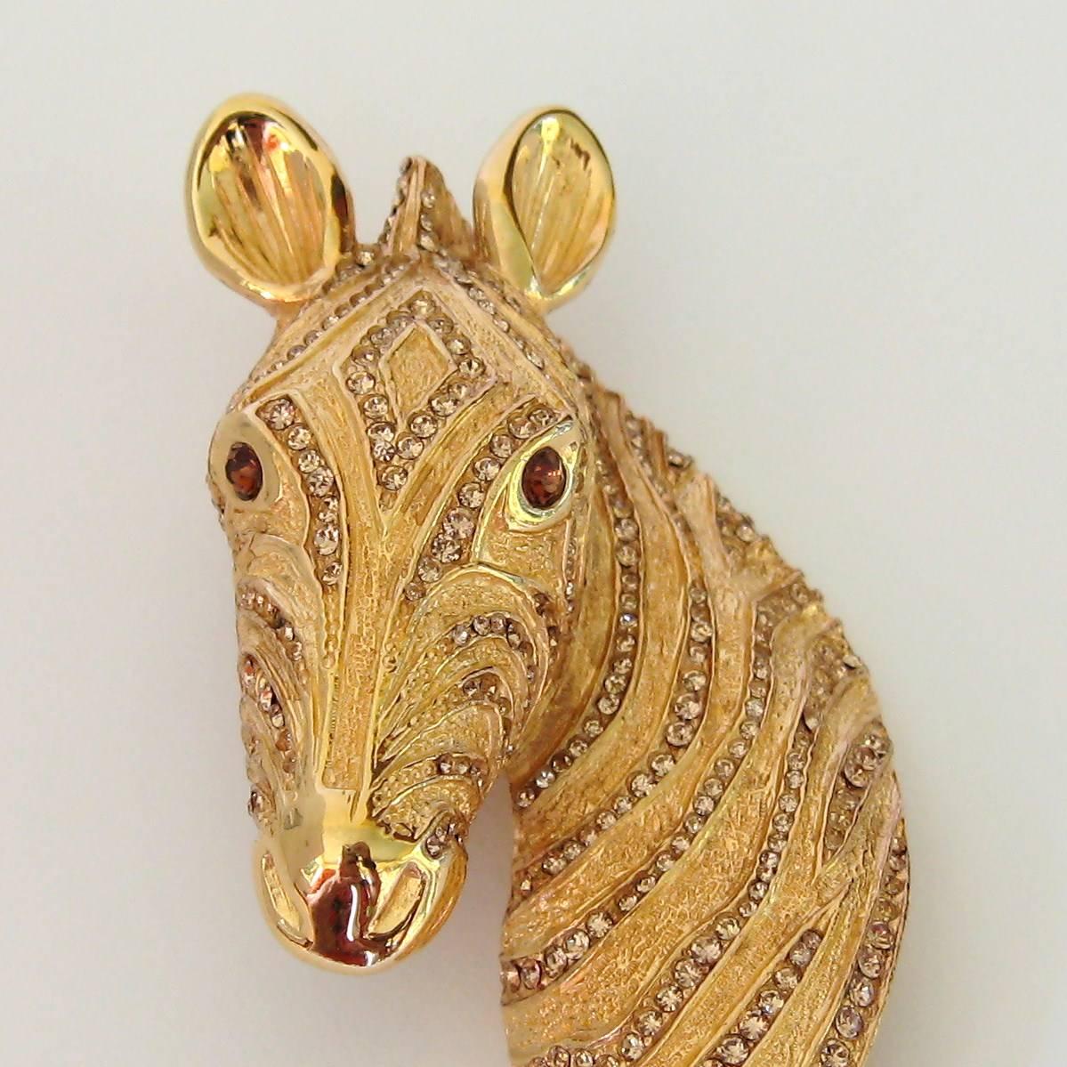 Wunderschöne Pferdekopf-Anstecknadel mit Swarovski-Kristallen im Pave-Set. Granatfarbene Augen. Gepunztes Ciner. Maße 2,87