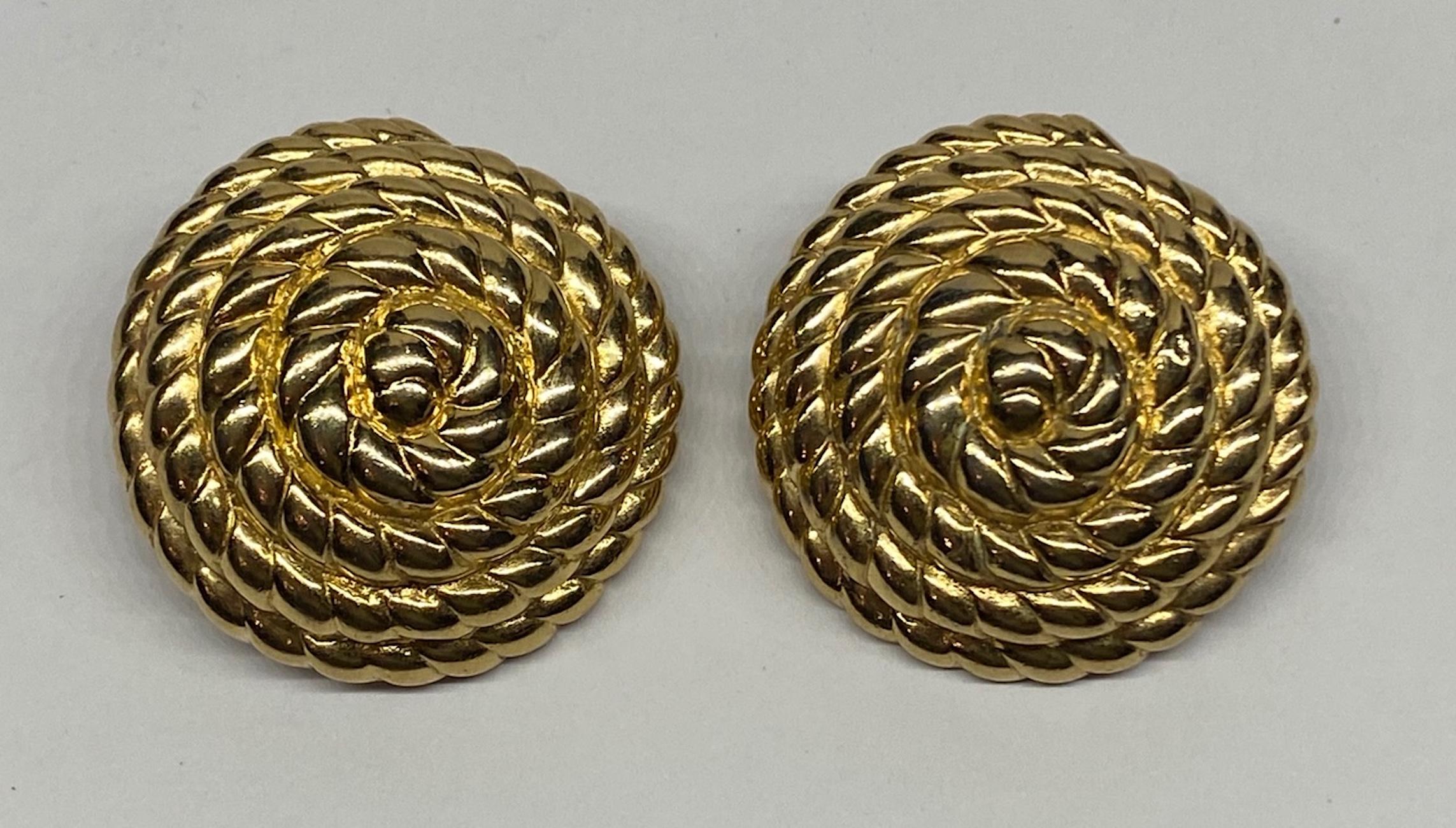 An elegant pair of nautical inspired button earrings of coiled rope design by American fashion jewelry company Ciner of New York City. Each earring is domed in shape and measures 1.25 in diameter an .5 of an inch high not including the clip. Each