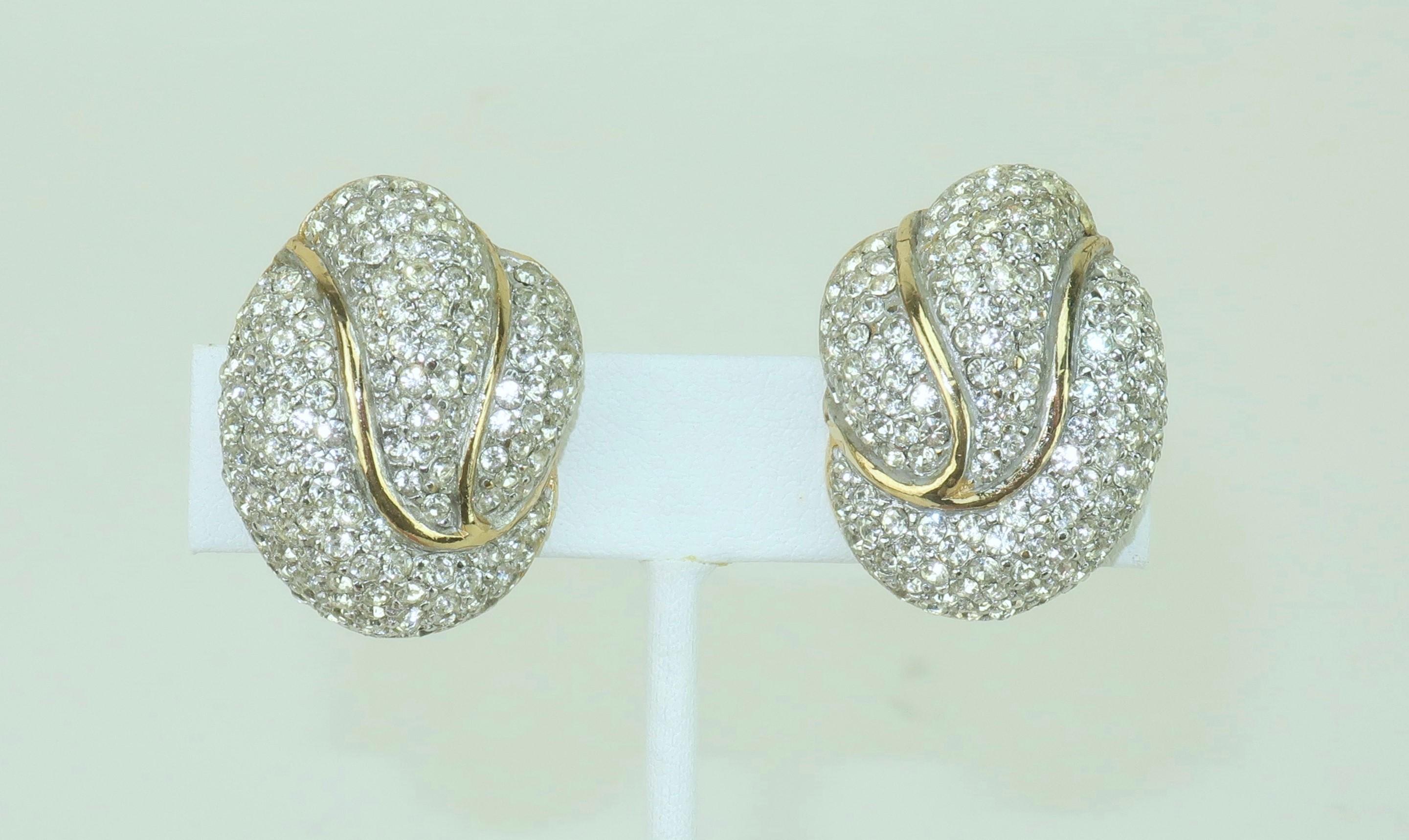 1980’s super glam crystal rhinestone earrings set in gold tone metal by Ciner, an American costume jewelry company known for producing high quality accessories since the 1930's.  The cluster shaped knotted design is eye catching.  Outfitted with