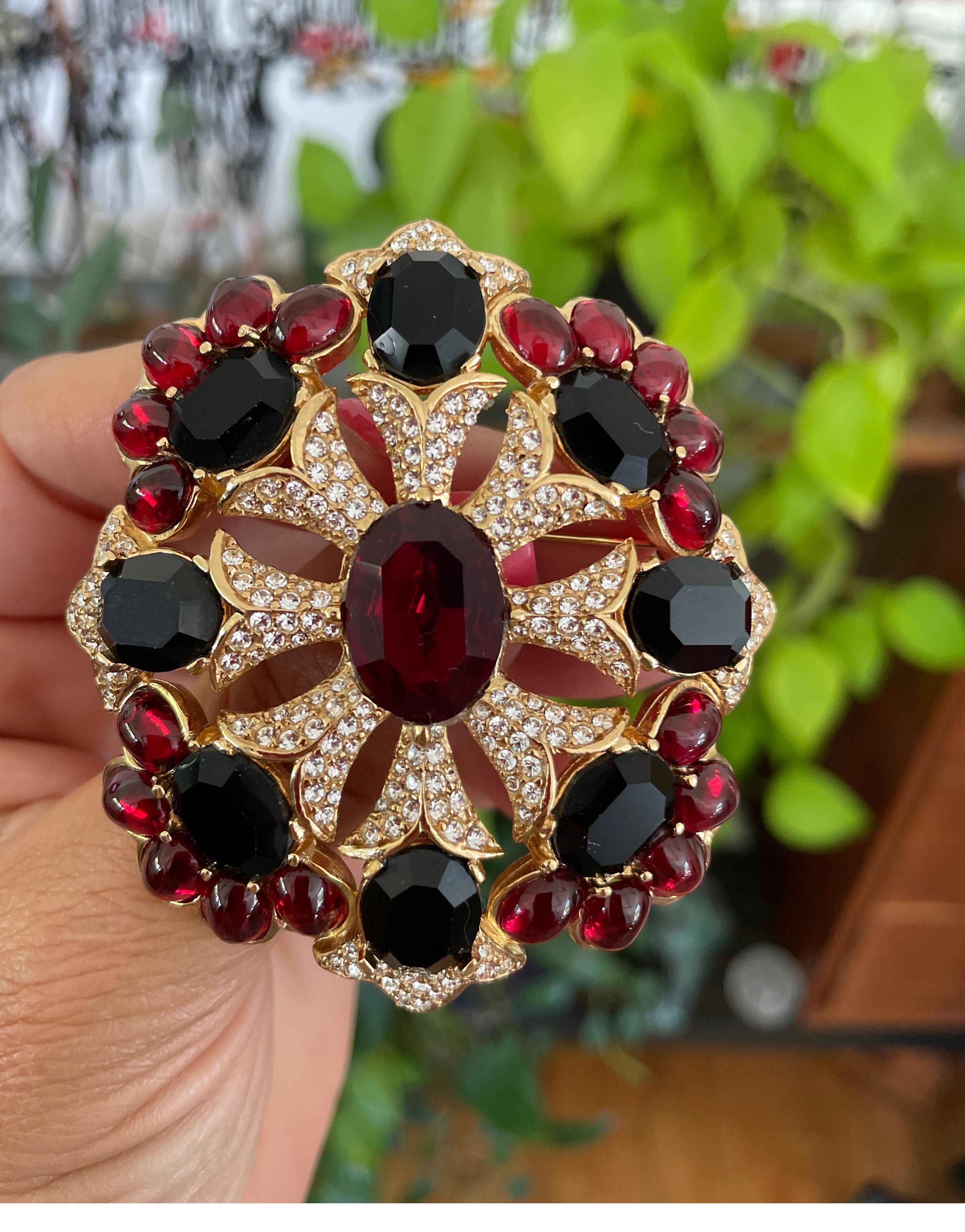 This is both a brooch and a pendant. Has Red and what looks to be black Swarovski Crystals as well as deep red cabochons. Clear Crystals as well. It has a hook on the back to use as a pendant as well. This measures 2.5 inches x  2.5 inches. We have