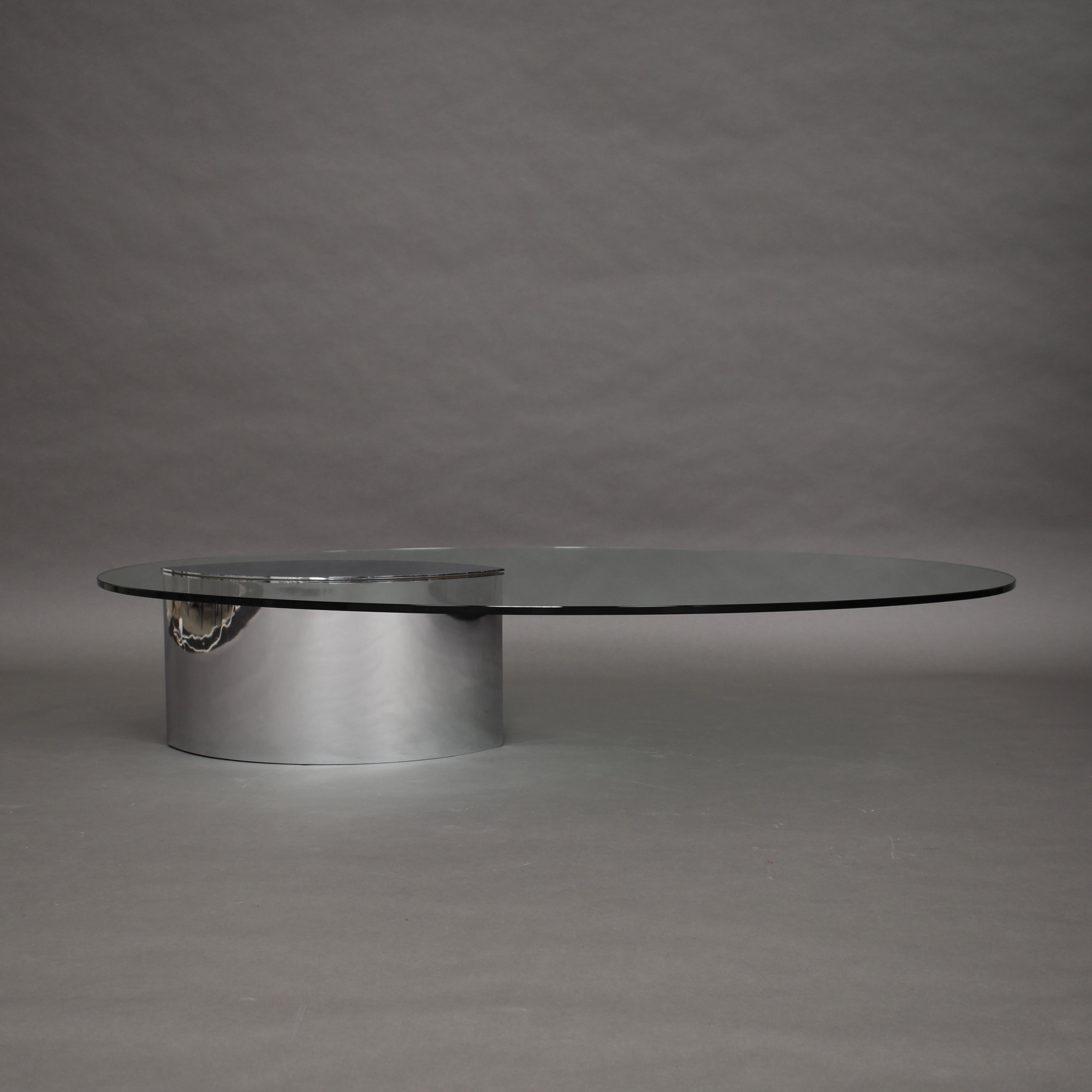 Cini Boeri coffee table in glass and chrome for GAVINA, Italy, circa 1970.

The glass top is kept in place by a chromed metal cover that is attached through holes in the glass onto the chromed base. The base has a heavy counter weight inside which
