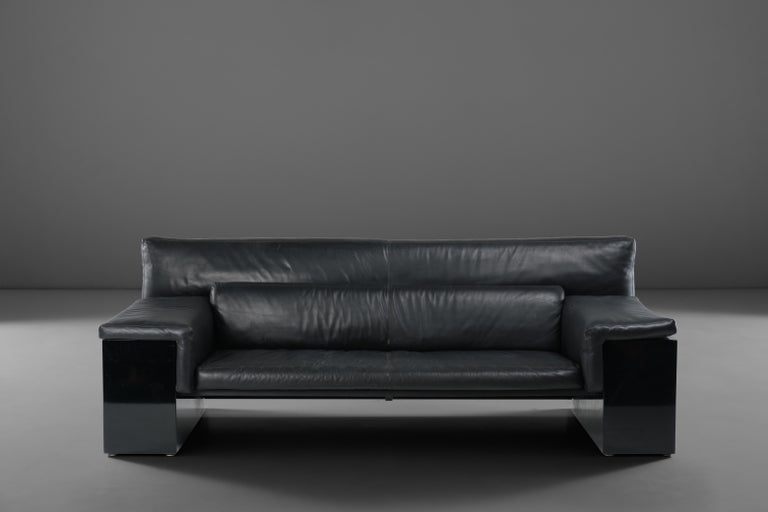 Architectural sofa model 'Brigadier' designed by Italian designer Cini Boeri for Knoll in 1976. This postmodern sofa is executed in refined black leather cushions which are hold together by a black lacquered geometrical wooden base.