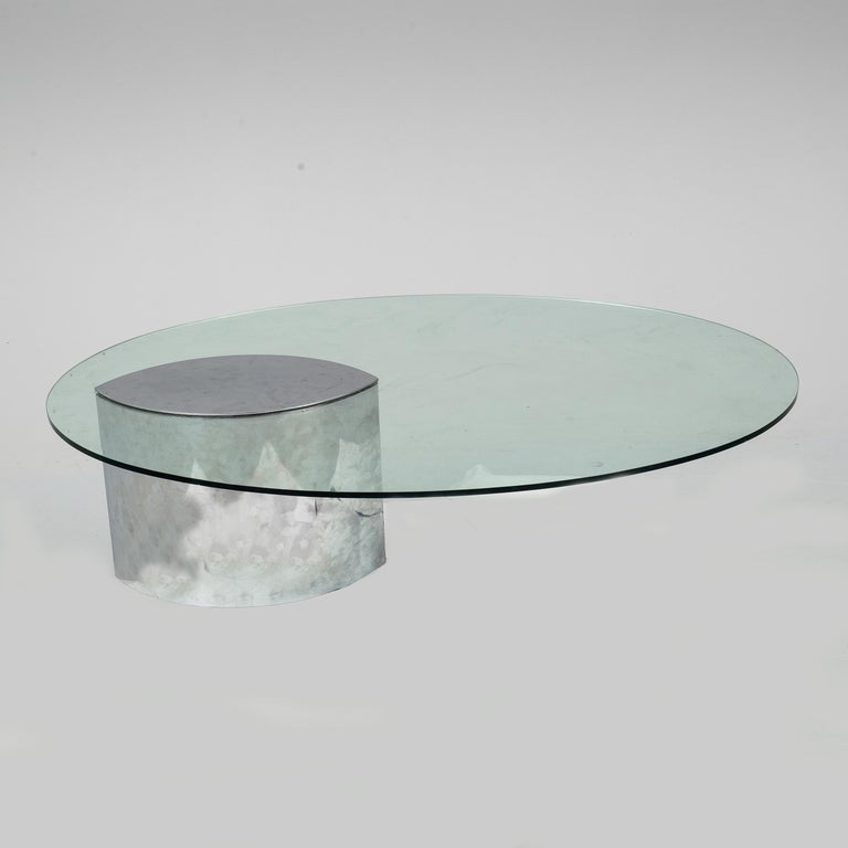 The Lunario coffee table from Knoll International features an oval glass plate and a metal base. It is characterized by its asymmetrical appearance and its simple and timeless design.

Vintage condition 

Minor Chrome loss on the upper edge of base,