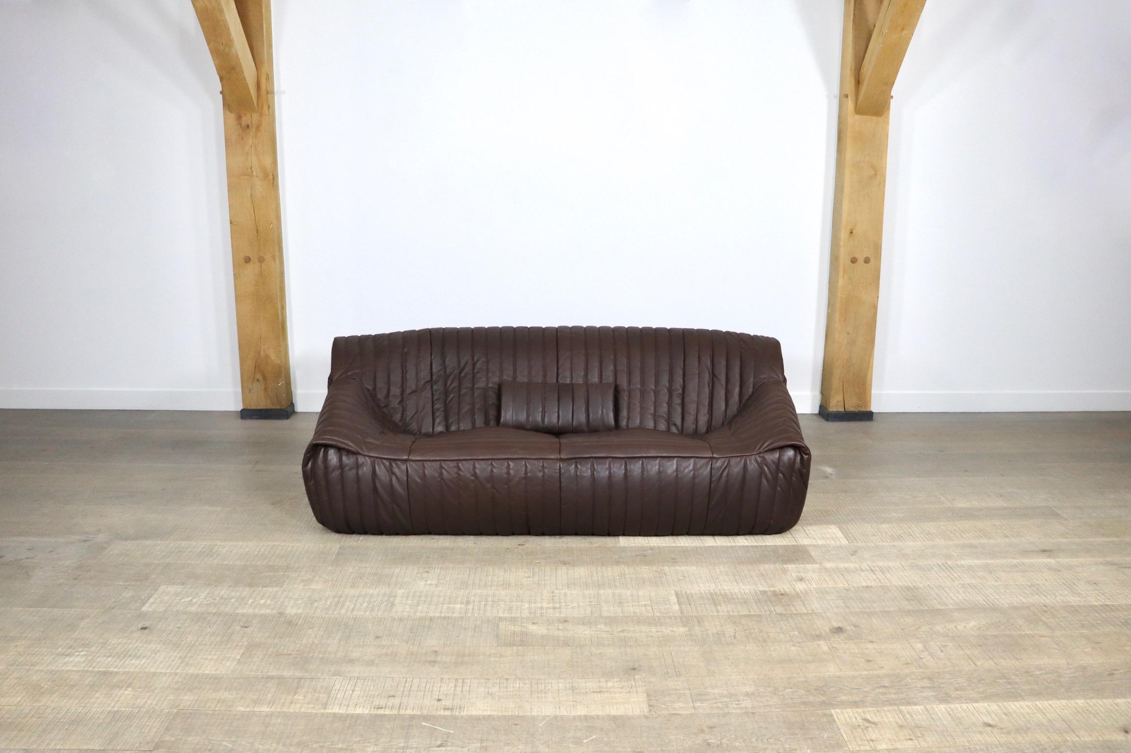 This very comfortable lounge three-seater sofa, model ‘Sandra’ was designed by Annie Hieronimus for Cinna in 1977 in France. The stunning high quality brown leather upholstery gives this sofa a luxurious feeling. The sofa has been produced in the