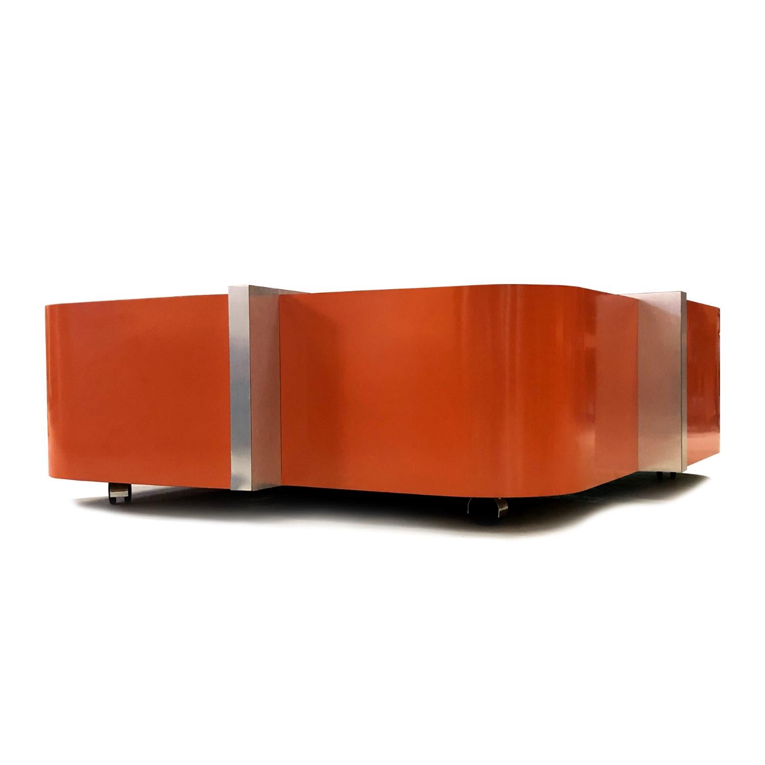 Bold is an understatement when it comes to the Cinnabar coffee table by Flair Home orange Mid-Century Modern coffee table. Everything about this table is loud. The table is a large rounded square separated into quadrants by panels of brushed