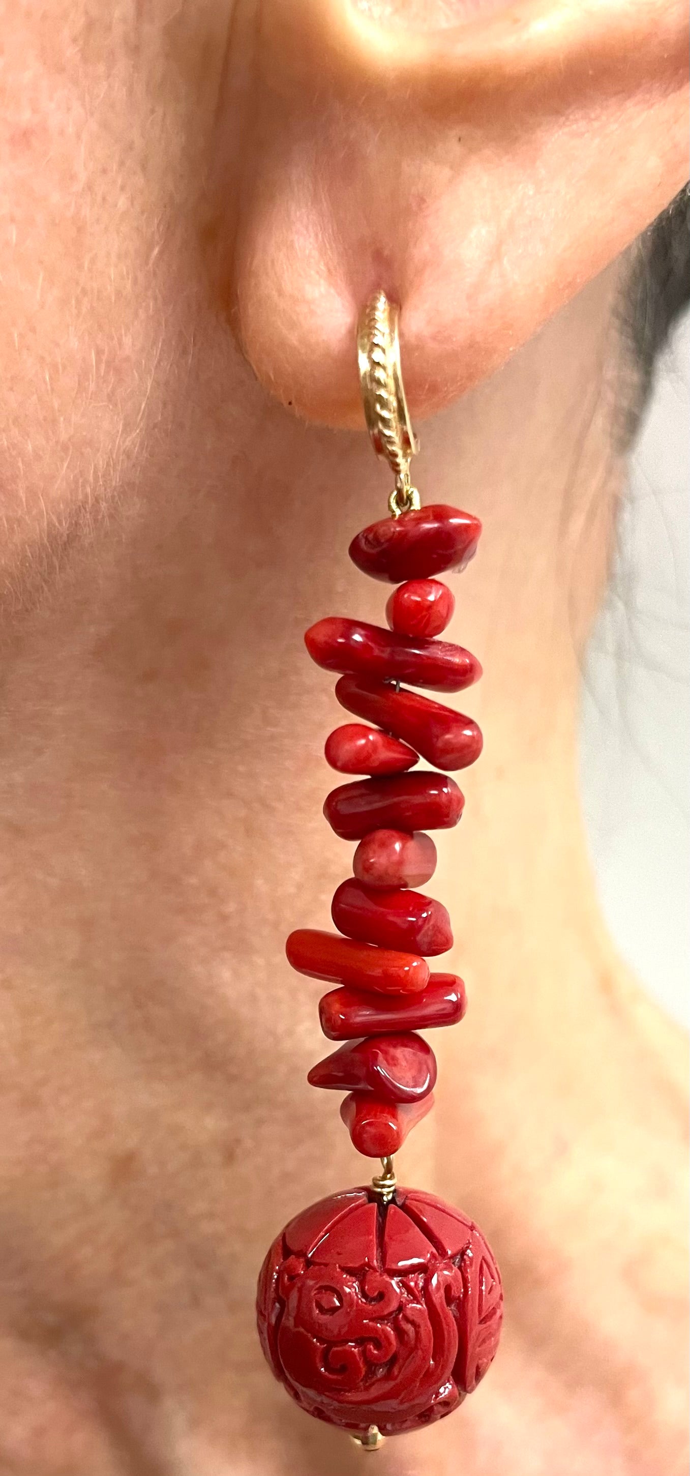 Description
These striking, fun and fashionable earrings are a mix of round carved cinnabar red resin balls and branch coral pieces, accented with faceted gold balls. In addition to the vibrant red color, the earrings dangle with flexibility and