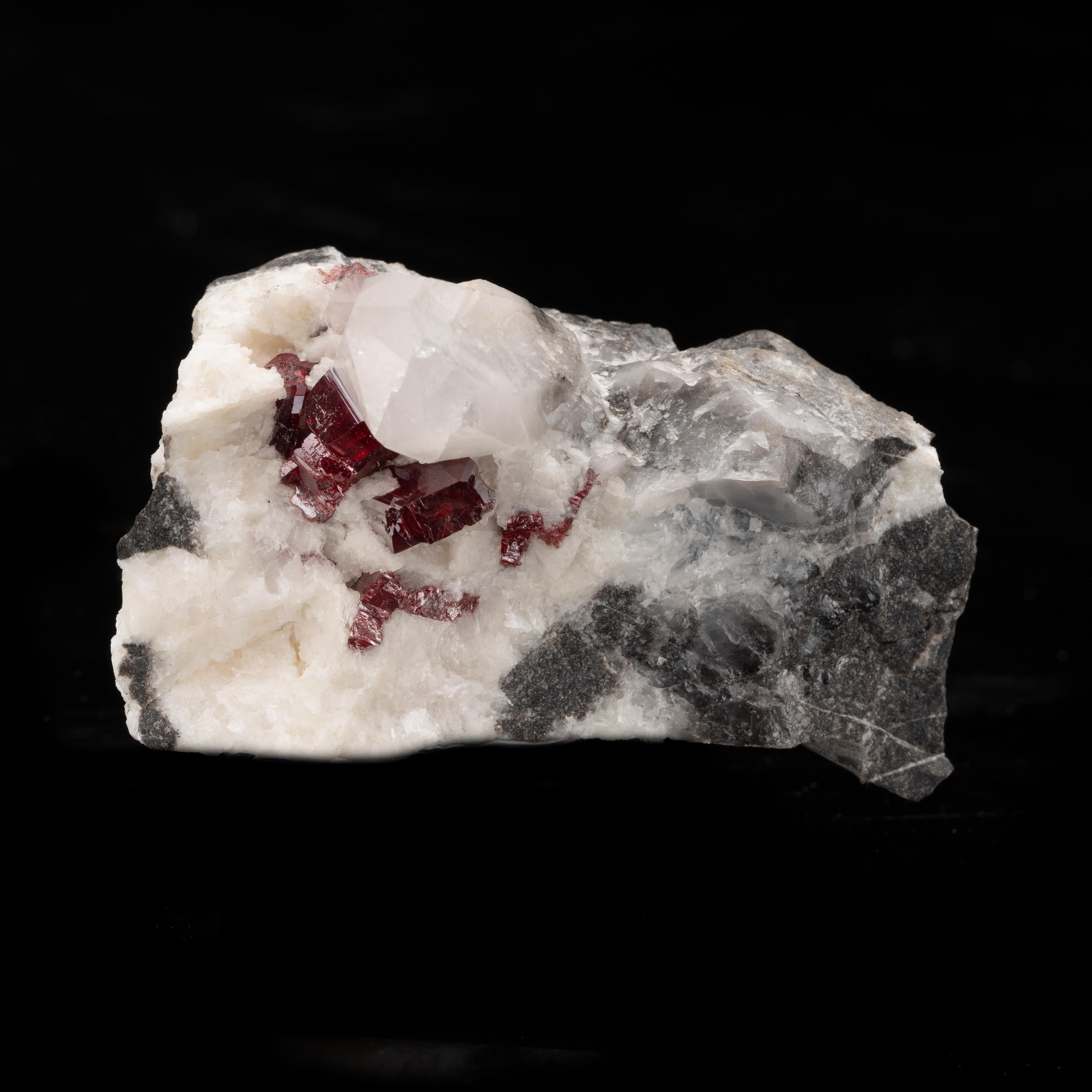 The lush red crystals juxtaposed in a snowy white and gray matrix are cinnabar, a mercury-rich ore historically found in China where this highly collectible specimen was sourced. Cinnabar was often used in ancient China as a pigment and in