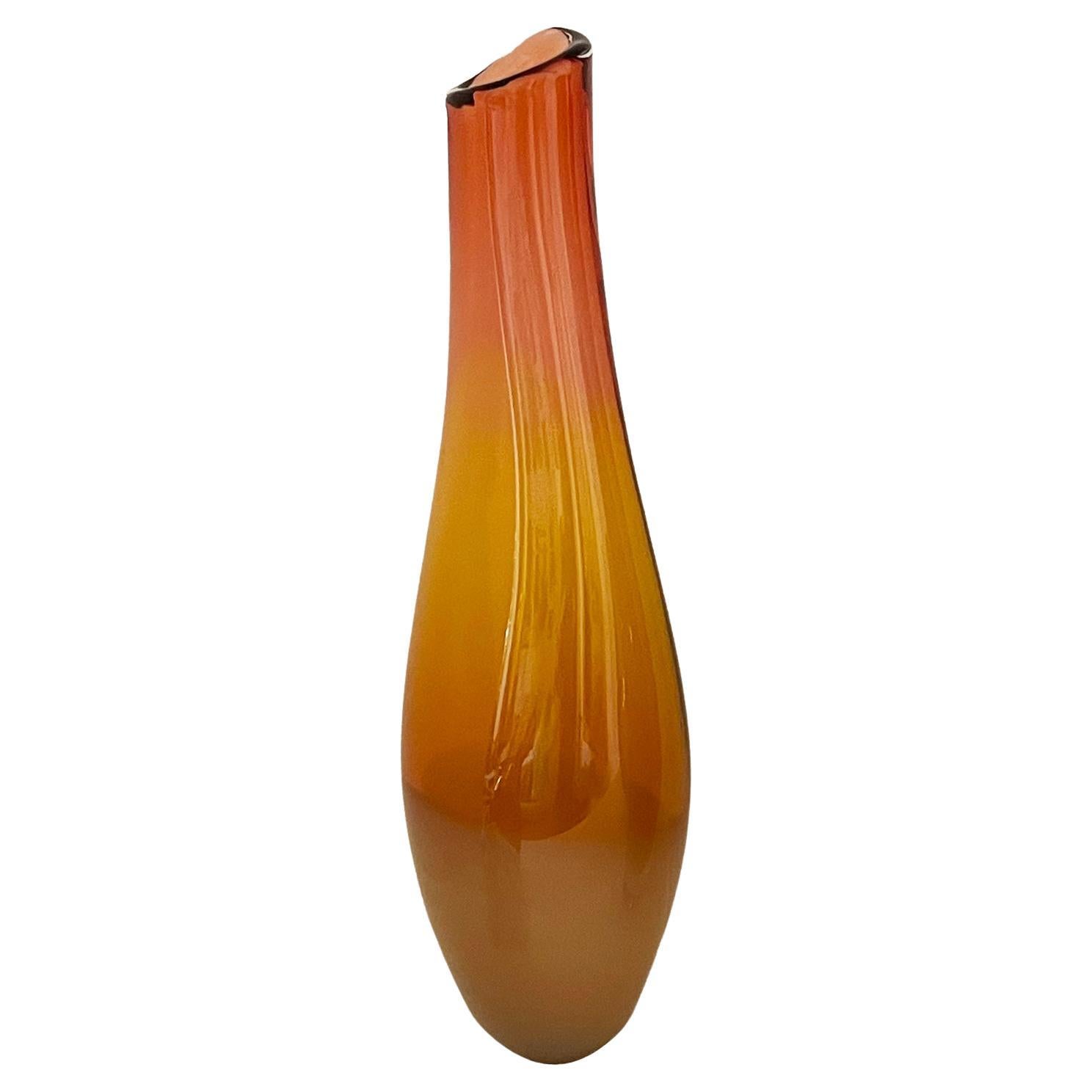 Unique blown glass vessel in cinnamon sun burst colours.
Shaped by hand in the form of a cigarillo. 
Narrow neck with shape tapering out towards bottom while still giving a slim elegant base.