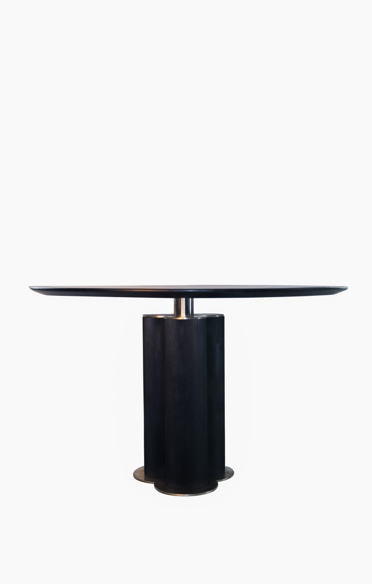 The Cinta dining table is a charcoal oiled walnut tabletop with charred linear textured base and brass details.


The aesthetic of this piece comfortably straddles the line between art and functionality, a philosophy that has drawn inspiration from