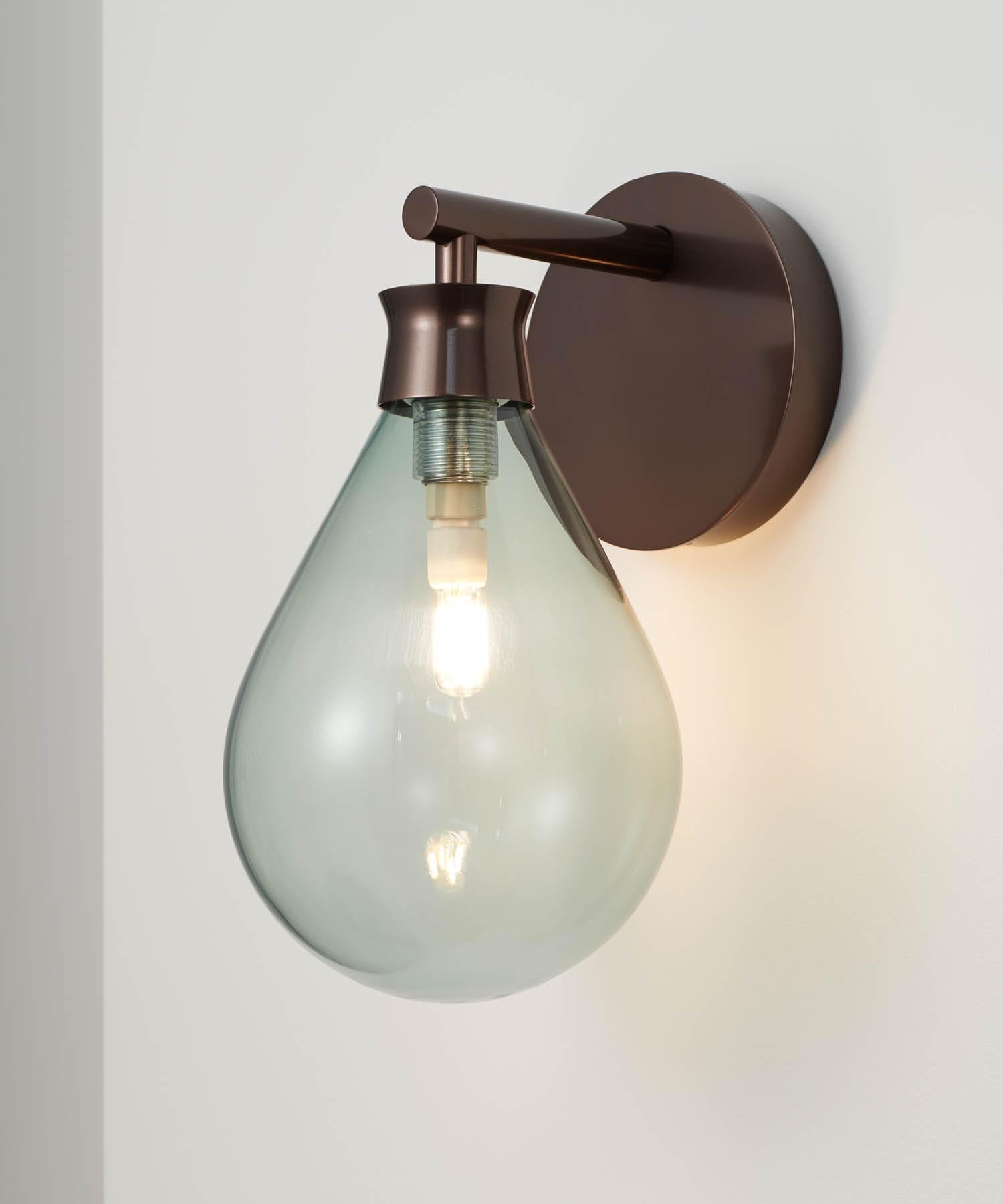 Contemporary and refined, the Cintola Wall Light combines hand-blown glass with a precision-machined aluminium body. Available in a selection of three glass colours and three metal finishes, the wall light can also be mounted in two different