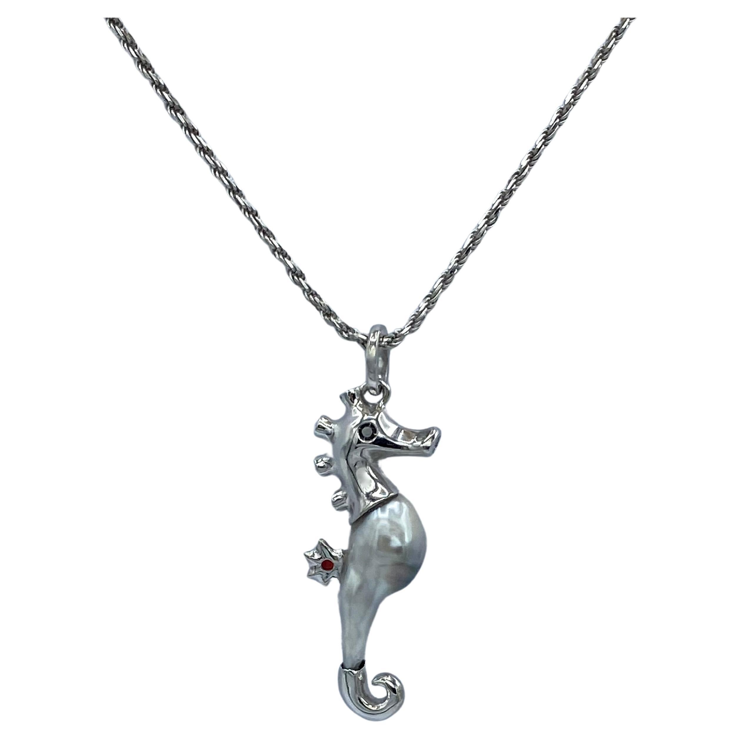 The elongated and distinctive shape of that keshi pearl inspired me to make a seahorse.
I created with wax and then cast in 18Kt white gold, the head, tail and dorsal fin.
The eyes are two black diamonds, in the mouth opening is a white diamond, and