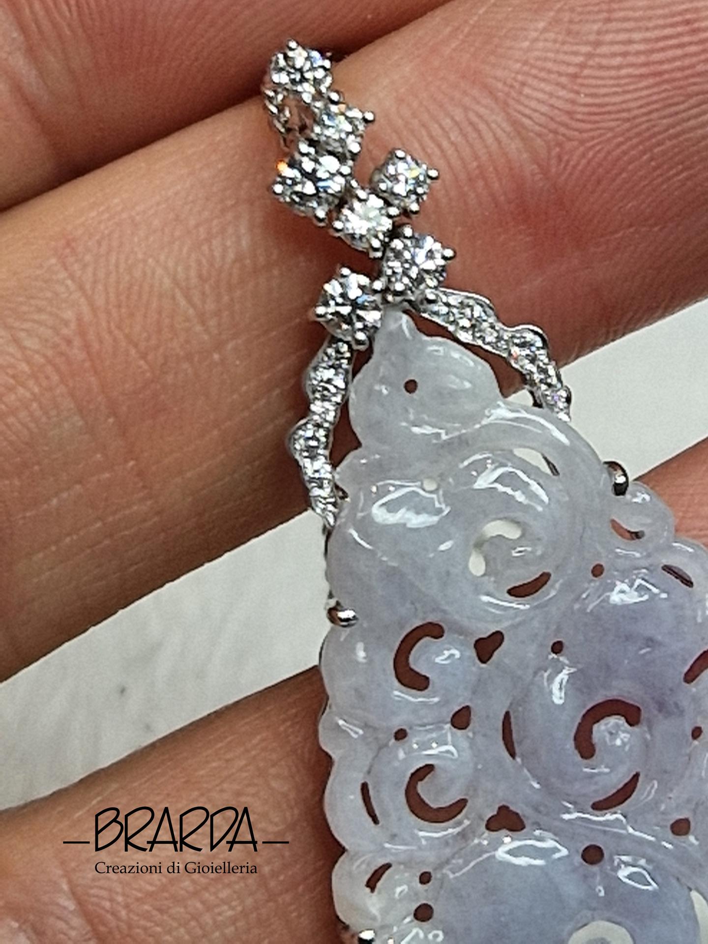 I ciondoli in Giada sono simblo di raffinatezza, in questo caso il piastra di Gadeite Birmana (grado B) è di un elegante tono glicine/lavanda finmente incisa ed intagliata a motivi orientali. L'abbinamento con i Diamanti naturali, (colore F+ purezza