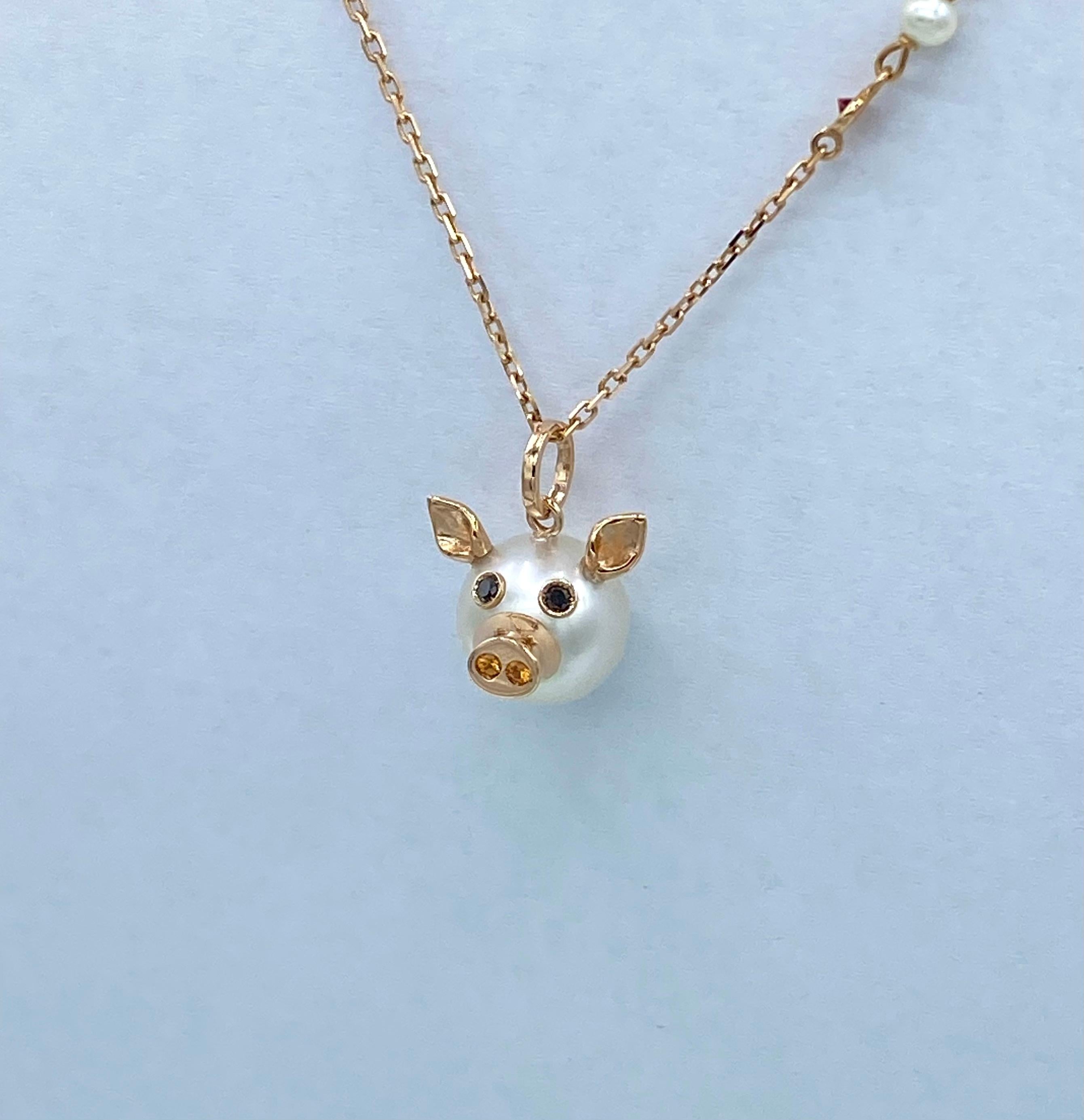 18KT rose gold piglet pendant with Australian pearl, diamonds and sapphires.
With an Australian pearl  button I made a piglet pendant; I added the nose, ears and eyes.
All gold elements are 18Kt rose gold. The eyes are set with two natural black