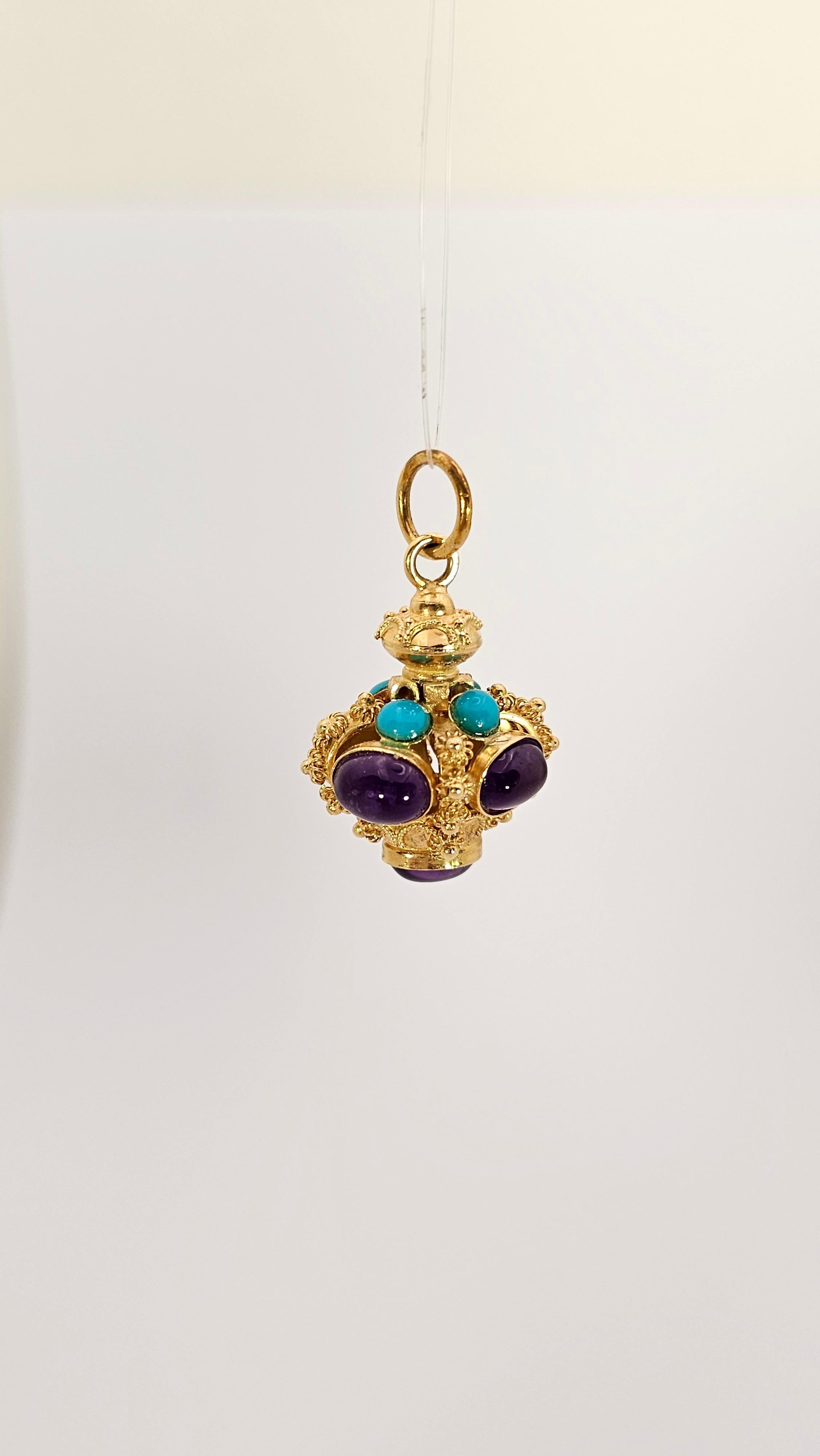 A Vintage Baroque-style pendant made of 18 kt gold and embellished with 5 oval cabochon-cut Amethysts and 4 round cabochon-cut natural Turquoises.
This crown-shaped pendant has meticulous craftsmanship in every detail.
The counter link has a