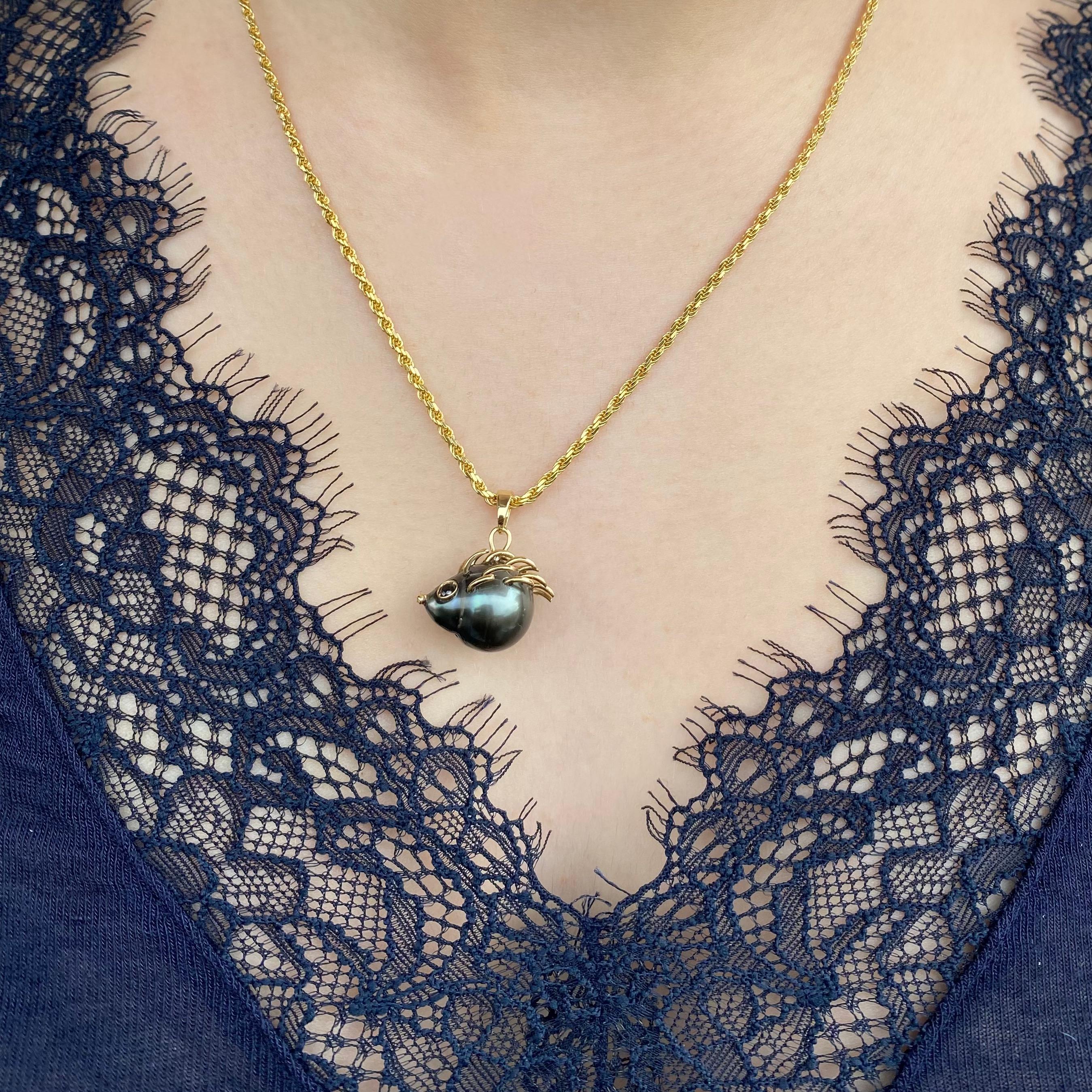 Un pendentif sculptural raffiné, entièrement réalisé à la main à partir de la forme naturelle d'une précieuse perle de Tahiti, transformée en un élégant porc-épic.

La surface de la perle, avec ses teintes irisées profondes, dialogue harmonieusement