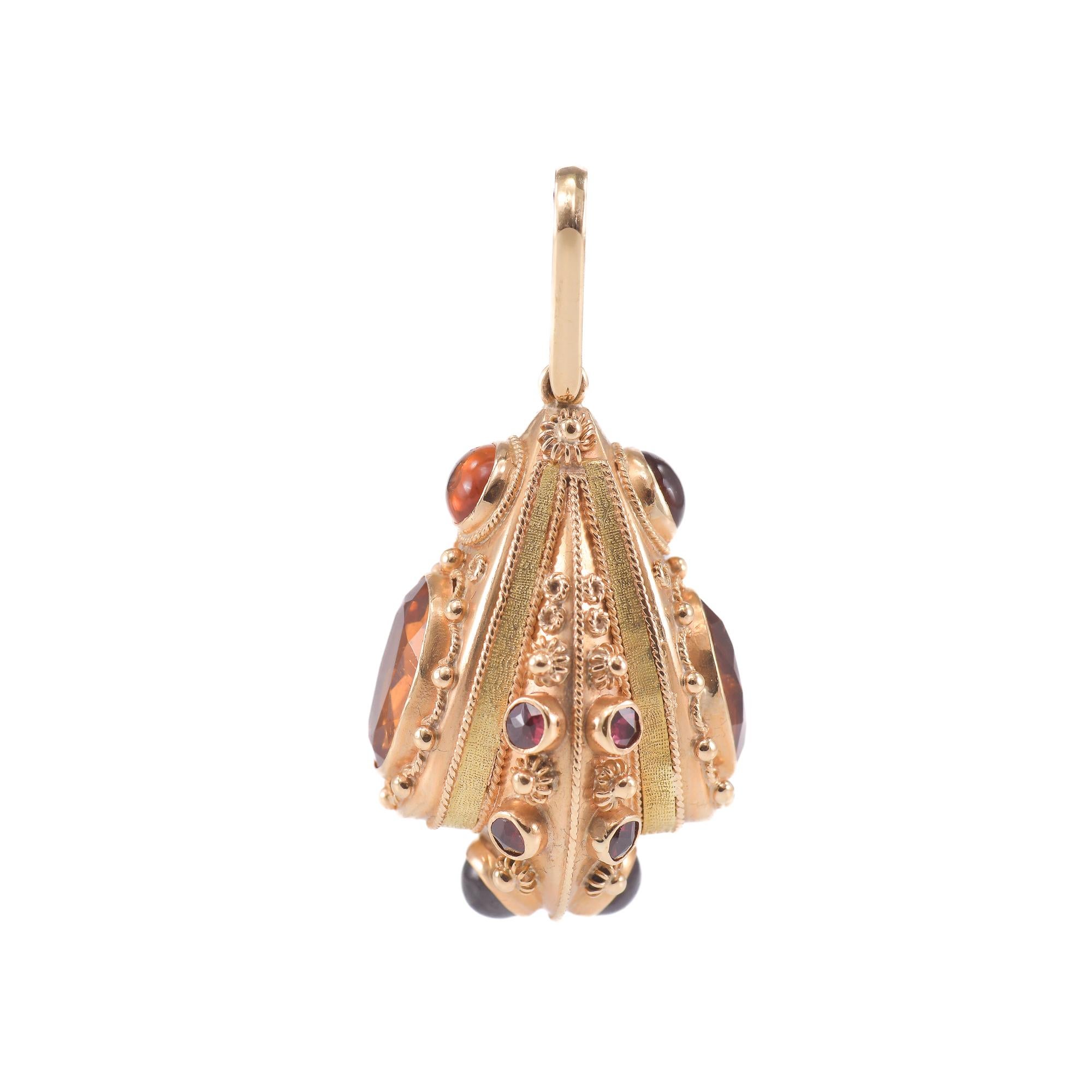 Anhänger aus 18k Gelb- und Roségold (750/1000) mit 10 dunkelrot-violetten Almandini-Granaten.
Form und Schliff: Rosette und runder Cabochon.
04 Gelb-orangefarbener Citrin-Quarz.
Form und Schliff: Zusammengesetzter ovaler und runder Cabochon.
Alle