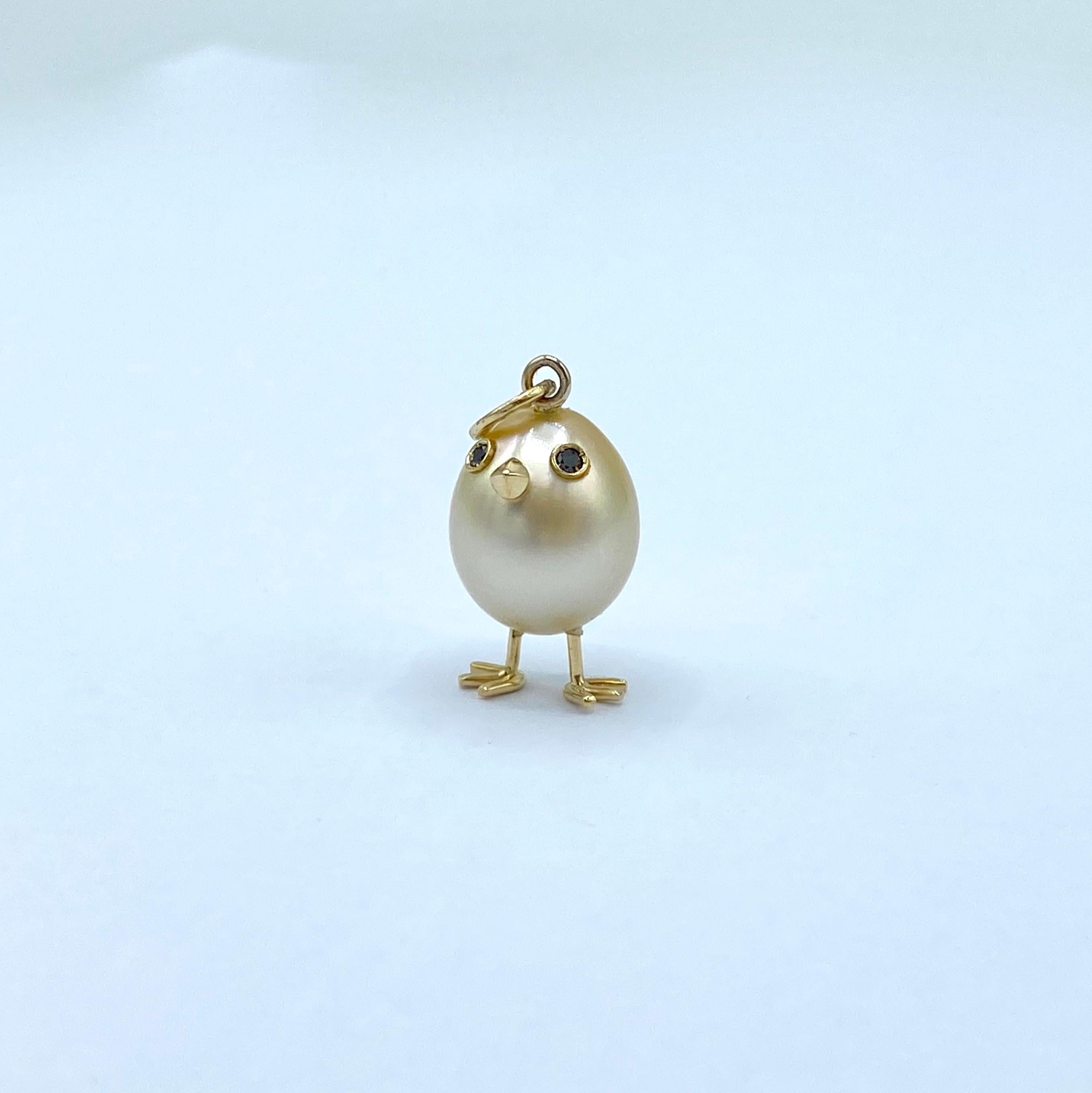 Made in Italy chick pendant in 18Kt gold Australian pearl and black diamonds
With a rare champagne-colored oval Australian pearl, a chick pendant was carefully crafted. 
It has two black diamond eyes, the beak, paws and chain ring are made of 18Kt
