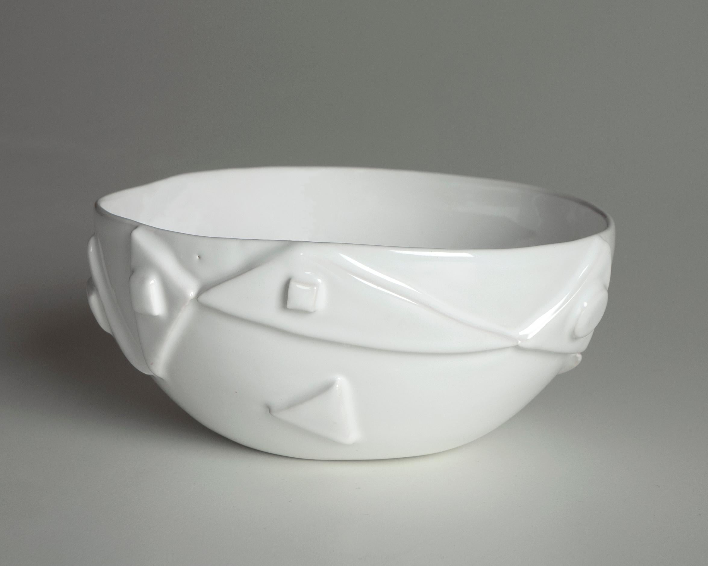 The white ceramic bowl is immersion glazed highlighting the relief decoration and its irregularities making it unique.