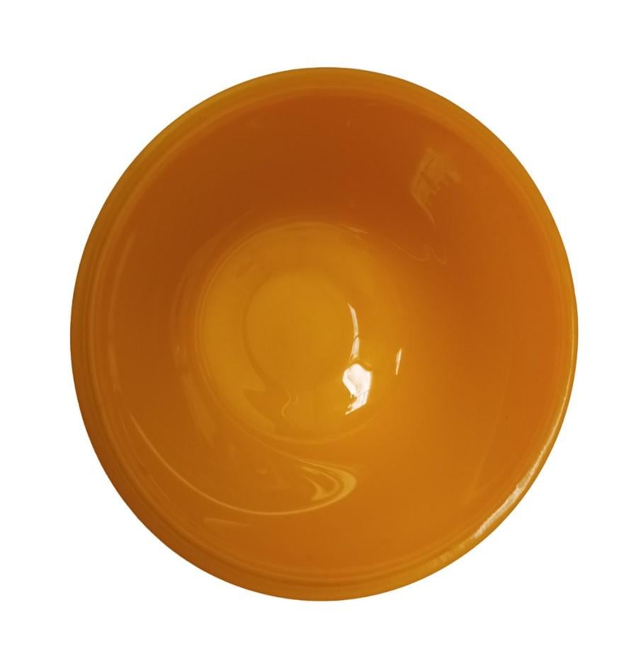 Bol chinois en verre épais, de forme simple et fonctionnelle, aux parois légèrement inclinées et au bord large et régulier. La surface lisse et brillante se caractérise par une teinte ocre jaune intense qui confère luminosité et chaleur à l'objet.