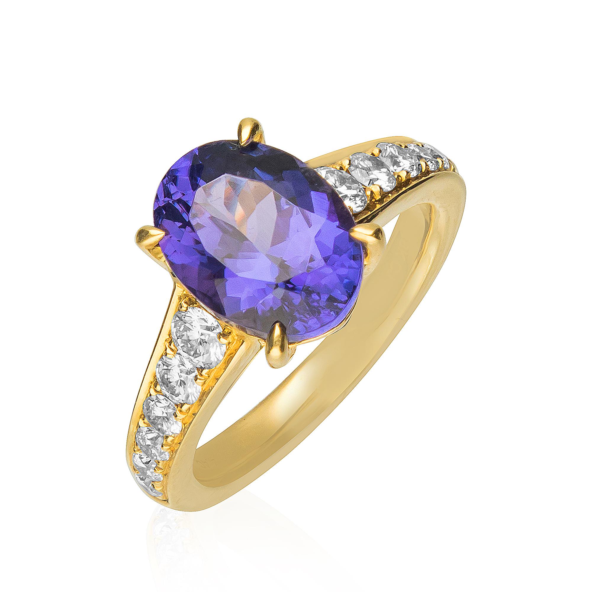 This traditional engagement ring is crafted in 18-karat Yellow gold. It features an Oval Shaped 4.40 Carat Tanzanite measuring 8X11 mm, 2 Round Diamonds 0.28 Ct. and 10 Round Diamonds 0.41 Ct. GH- SI quality in prong-setting. This ring comes in size