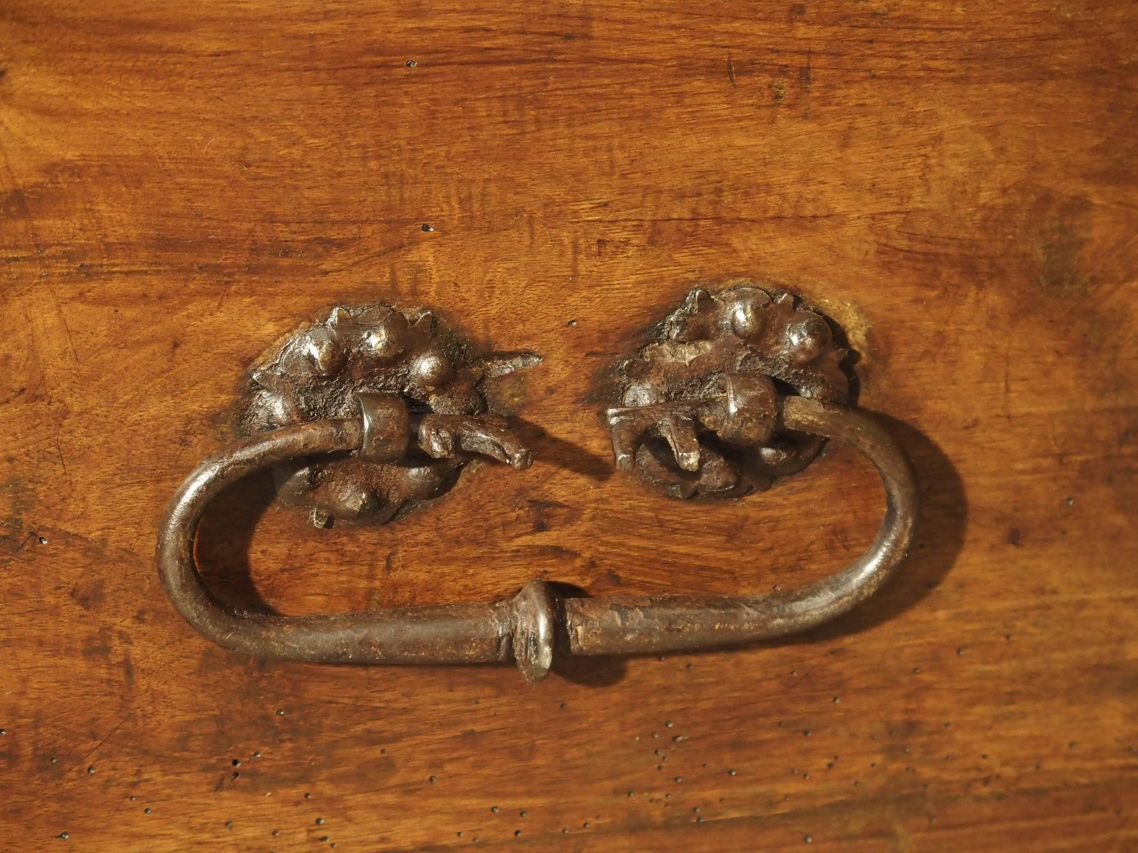 This amazing walnut wood trunk from Spain dates to the middle of the 17th century. It has unusually thick iron hardware in the form of floral motifs attaching the boards, and there are also longer iron straps along the inside back board. We usually