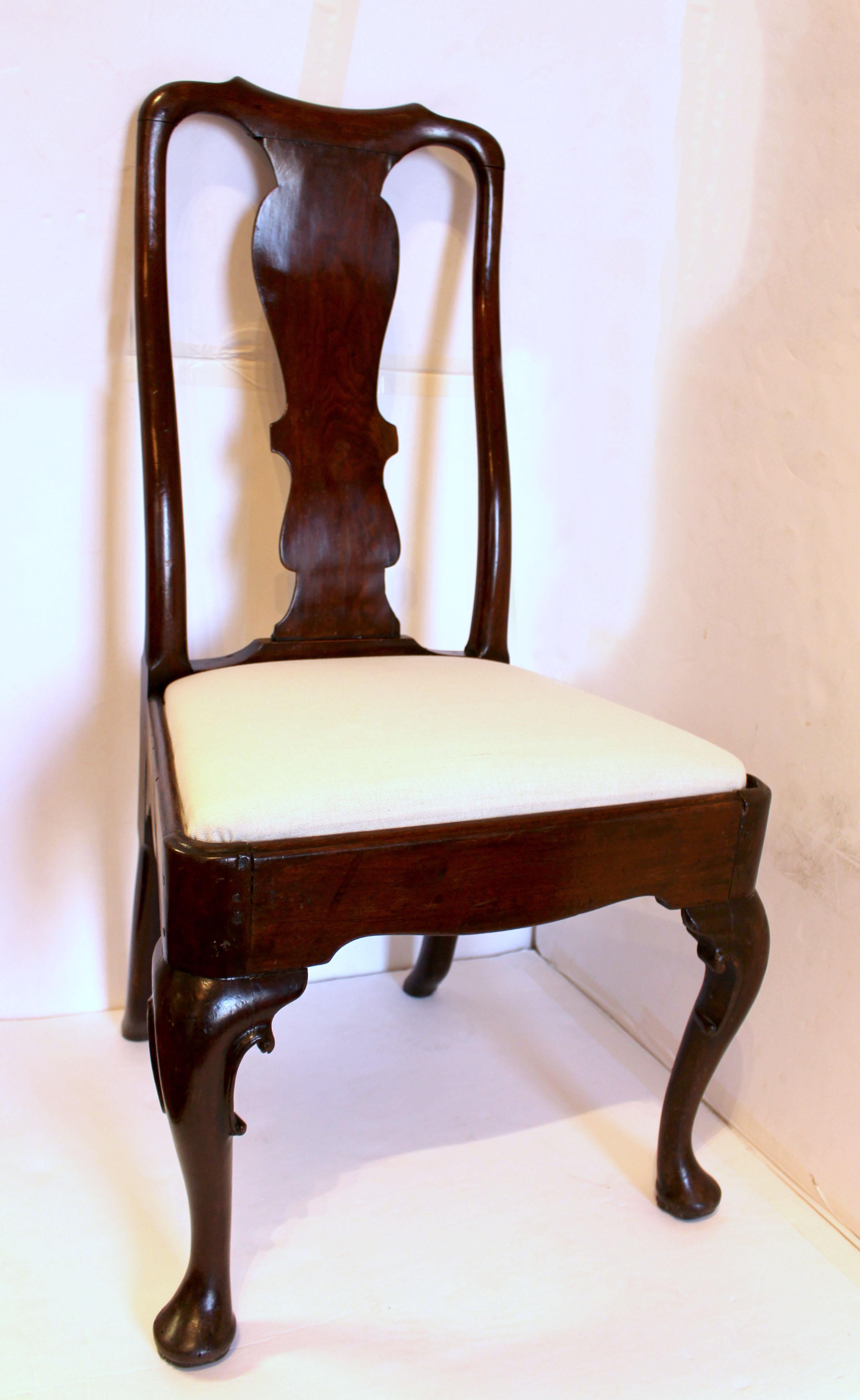 Circa 1720-40 Queen Anne side chair, English. Walnut. Raised on c-scroll carved well shaped cabriole legs ending in pad feet. Shaped returns. Outswept back legs. Typical shaped backsplat of the design era with well shaped crest rail.
21.25