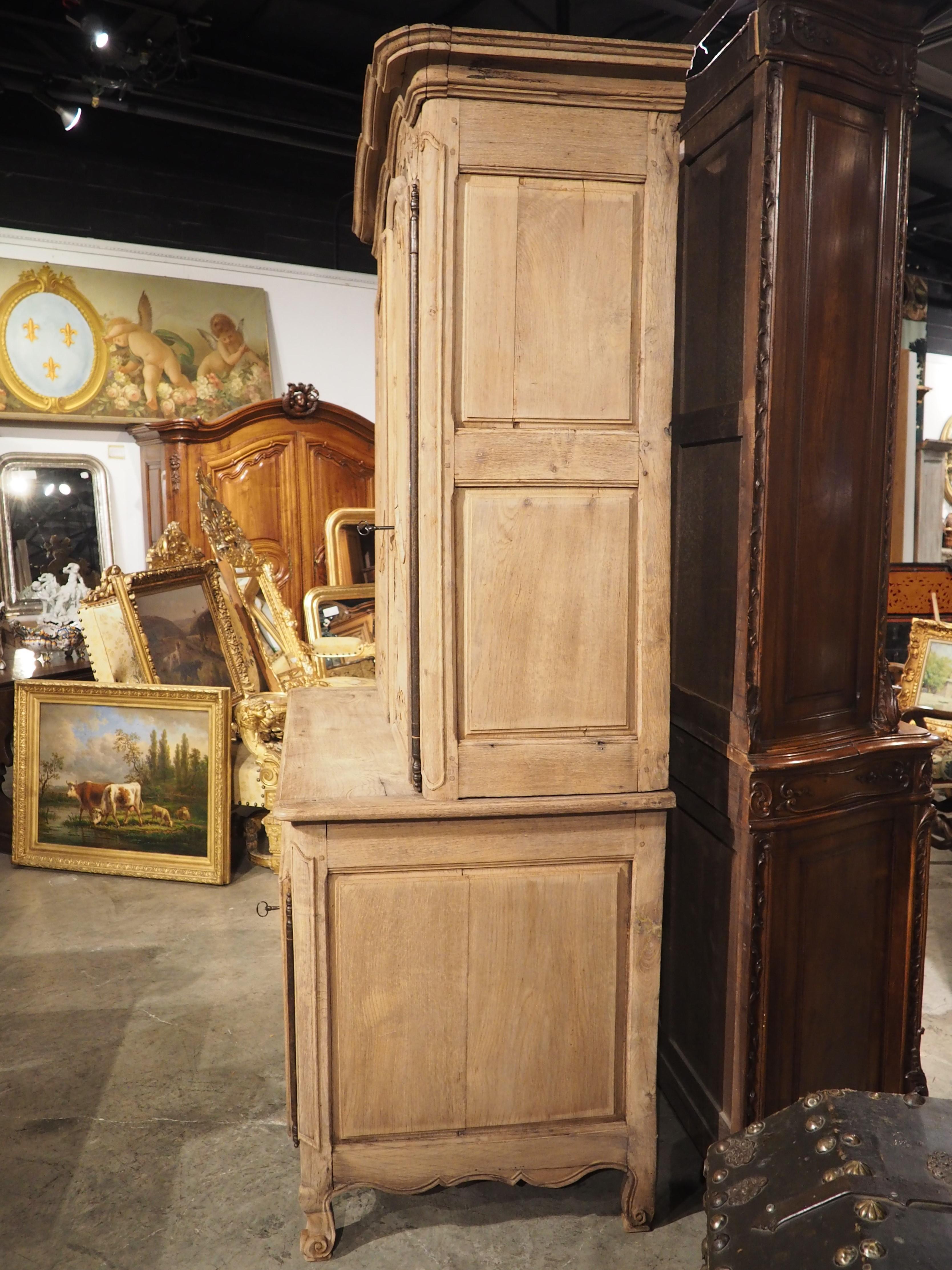 Hand-carved in Laval, France, circa 1730, this oak buffet deux corps has been bleached, allowing the motifs of the Louis XV cabinet to gain prominence. Laval is a town less than 200 miles west of Paris and its proximity to the capital allowed local