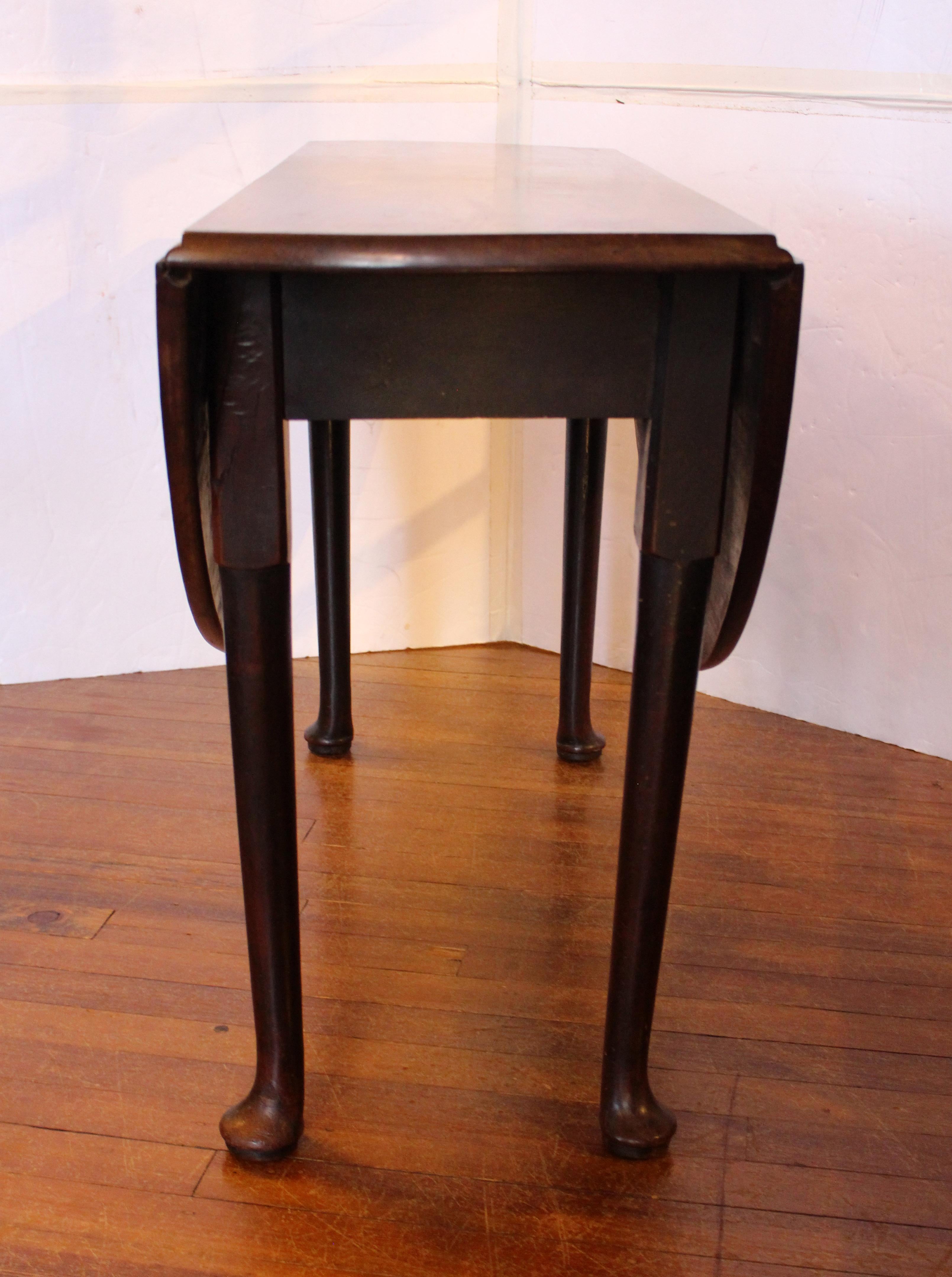 Circa 1740-60 George II drop leaf table, English. Queen Anne to Georgian transitional style. Simple, turned, tapered legs end in robust pad feet. Well figured wood of good color. Old break & restoration to upper section of one leg at the joint to
