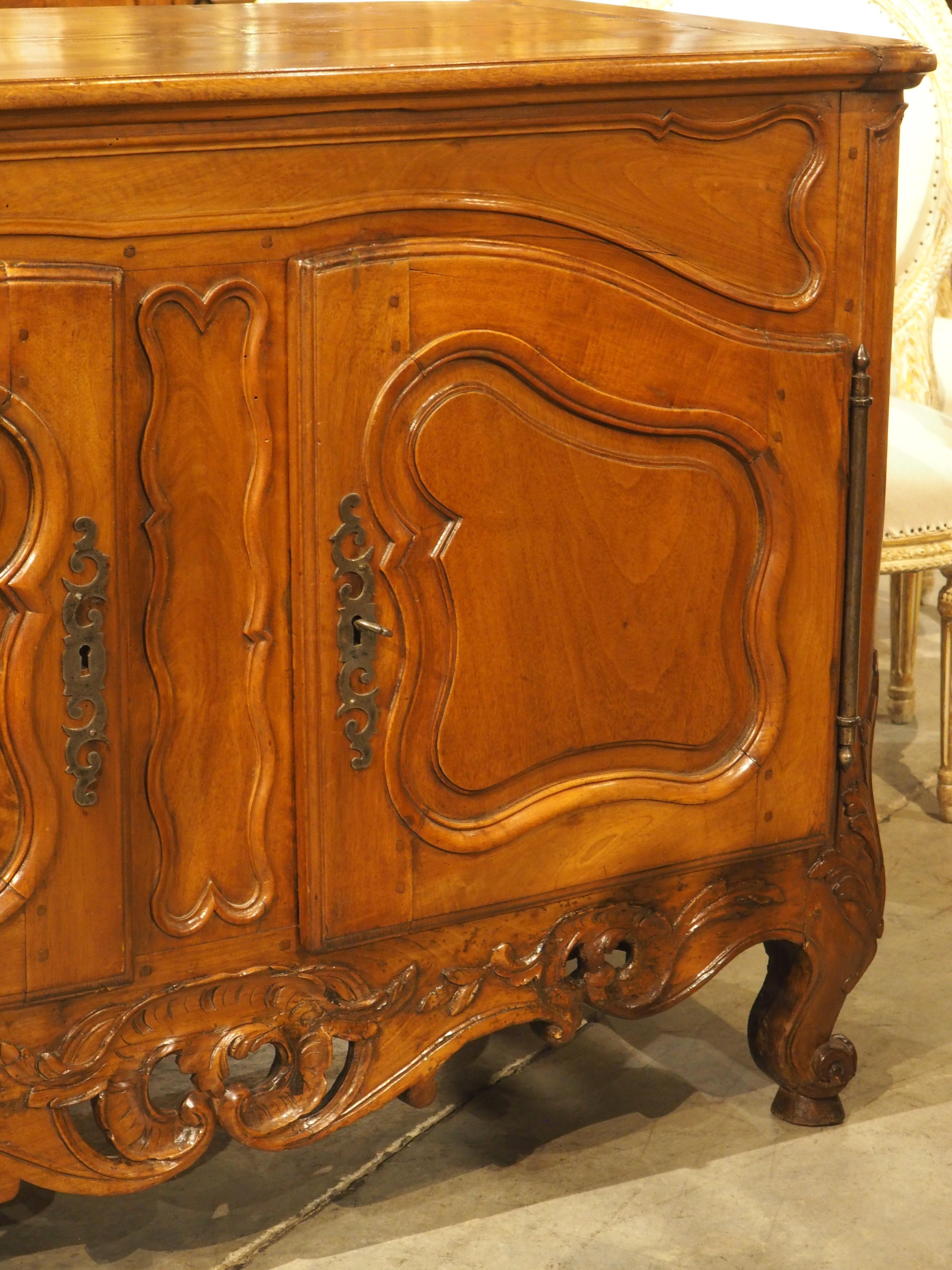 A stunning buffet from the period of Louis XV, this crédence (French for “credenza”) was hand-carved in walnut wood circa 1750 in Nimes, France. The deep carvings and moldings feature subtle asymmetry, which was a hallmark of the period.