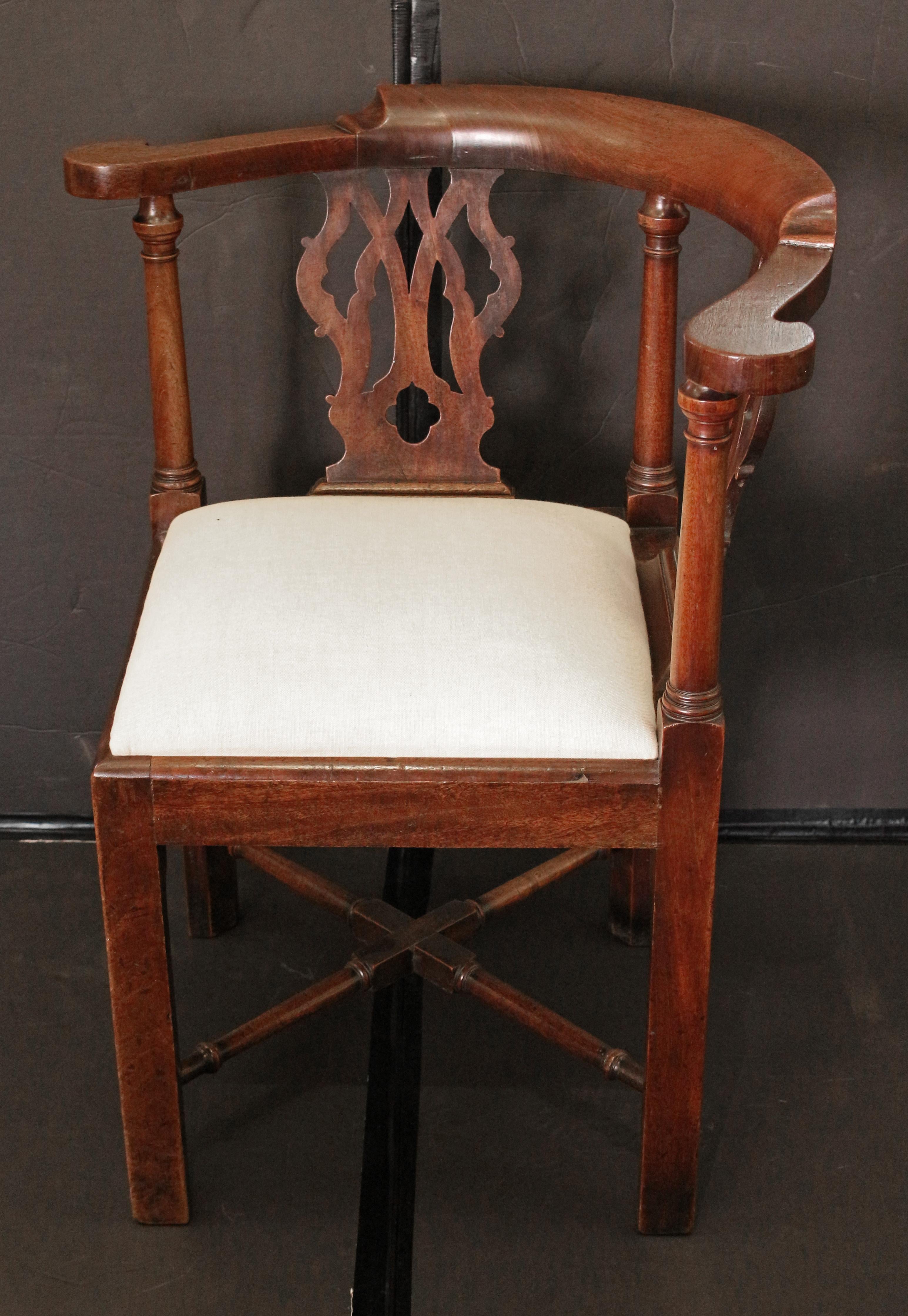 Circa 1760-80 George III period corner chair, English. Mahogany of good color. Once with deep aprons to likely conceal a chamber pot, now re-braced with and slip seat. Ring-carved, turned X form cross-stretcher. Straight, square legs with interior