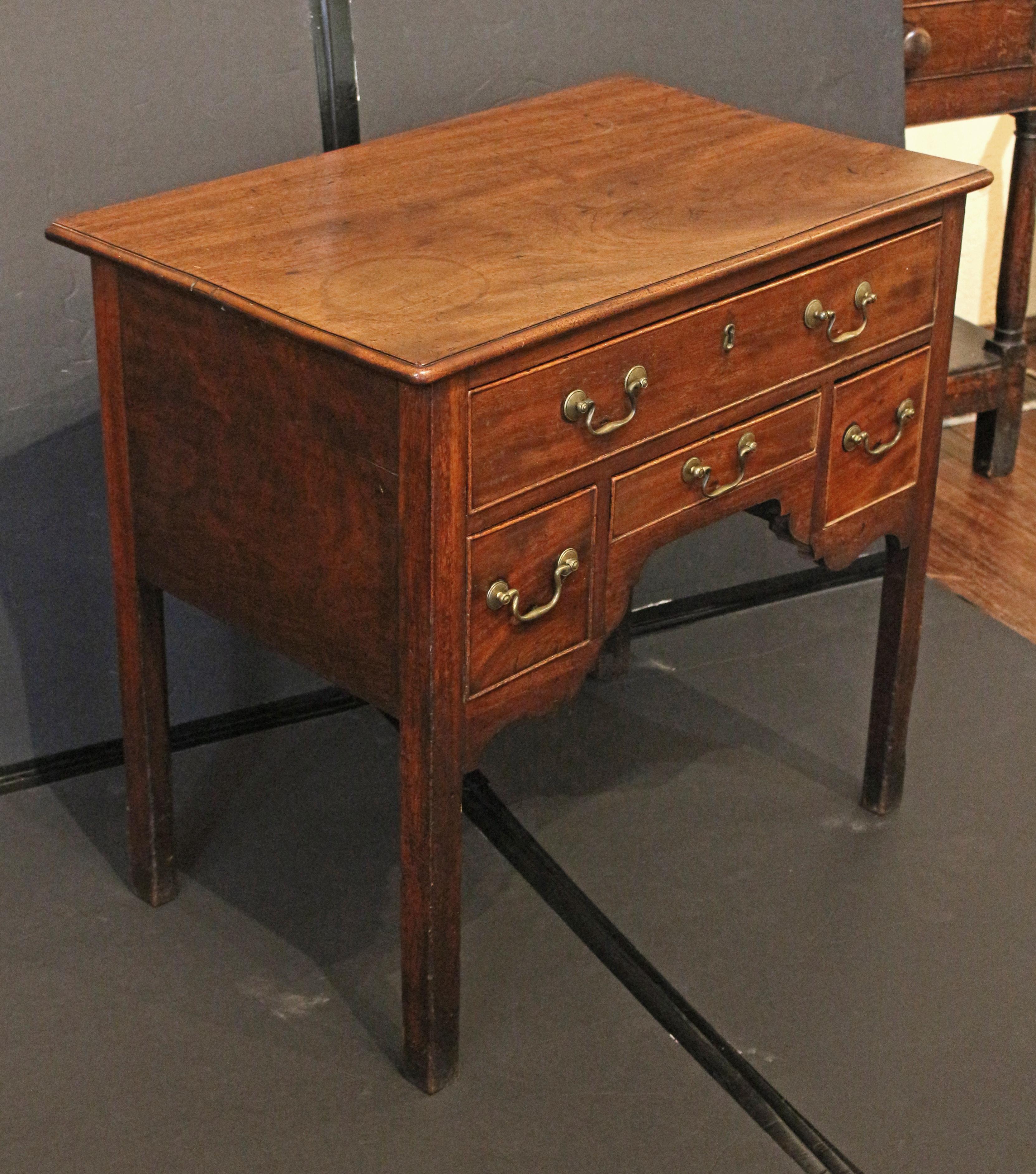 Circa 1760-80 George III period lowboy table, English. Well figured mahogany. One long drawer over central petite rectangular drawer flanked by square drawers, over very nicely shaped aprons. Raised on square legs, the feet tipped due to wear over