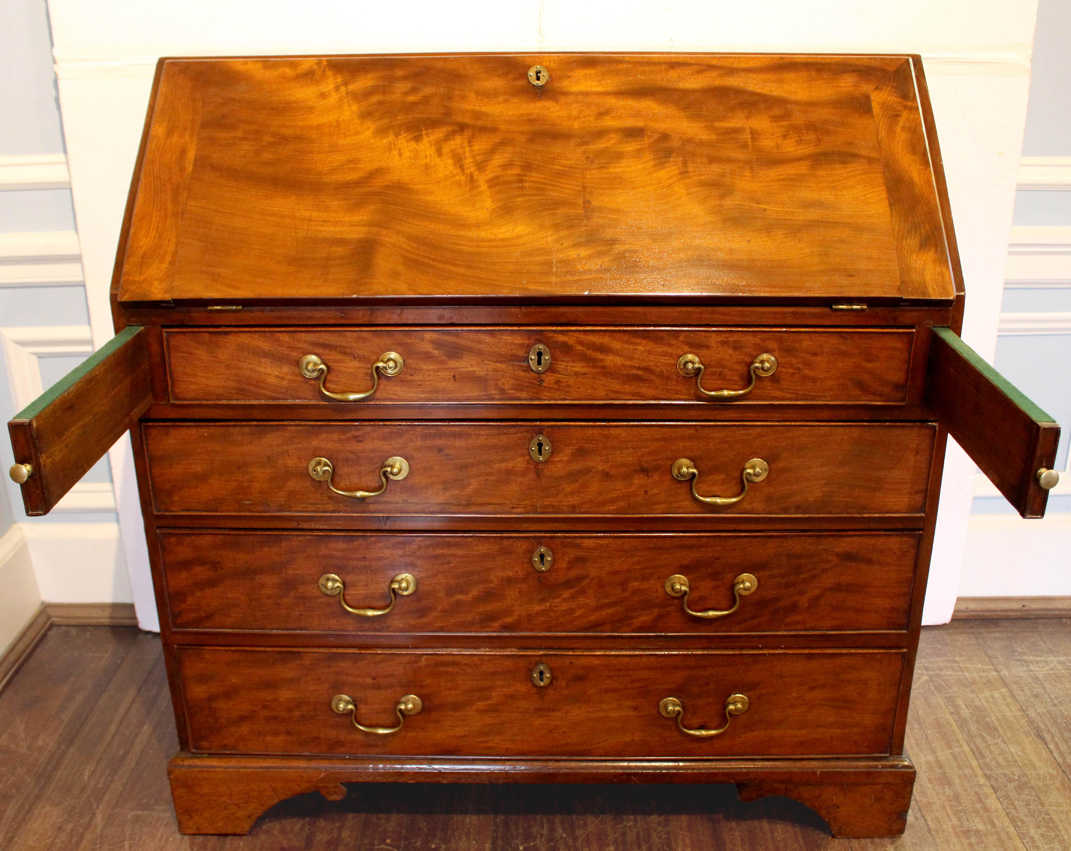 Circa 1760-80 George III period slant front bureau, English. Deep rich Cuban mahogany timbers. The interior is well fitted with 4 valanced pigeon holes above 2 long drawers, flanked by 2 ranks of three small drawers. Four long graduated drawers in