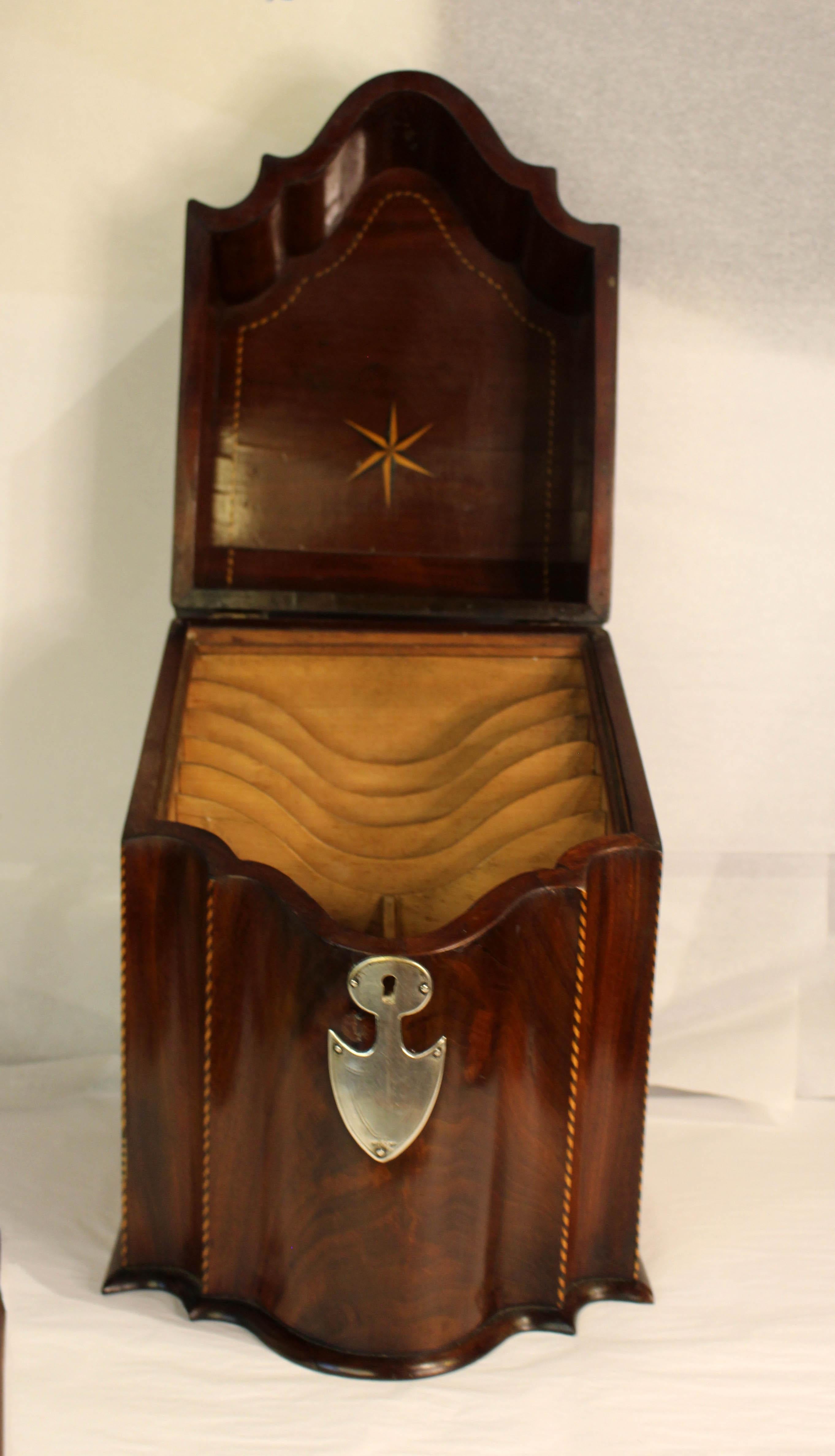 Circa 1760 knife box, George III, now fitted as a stationary box, English. Serpentine front. Barberpole stringing of ebony & boxwood line the top, edges, & interior lid, the latter also inlaid with a compass. Likely Old Sheffield silver escutcheon &