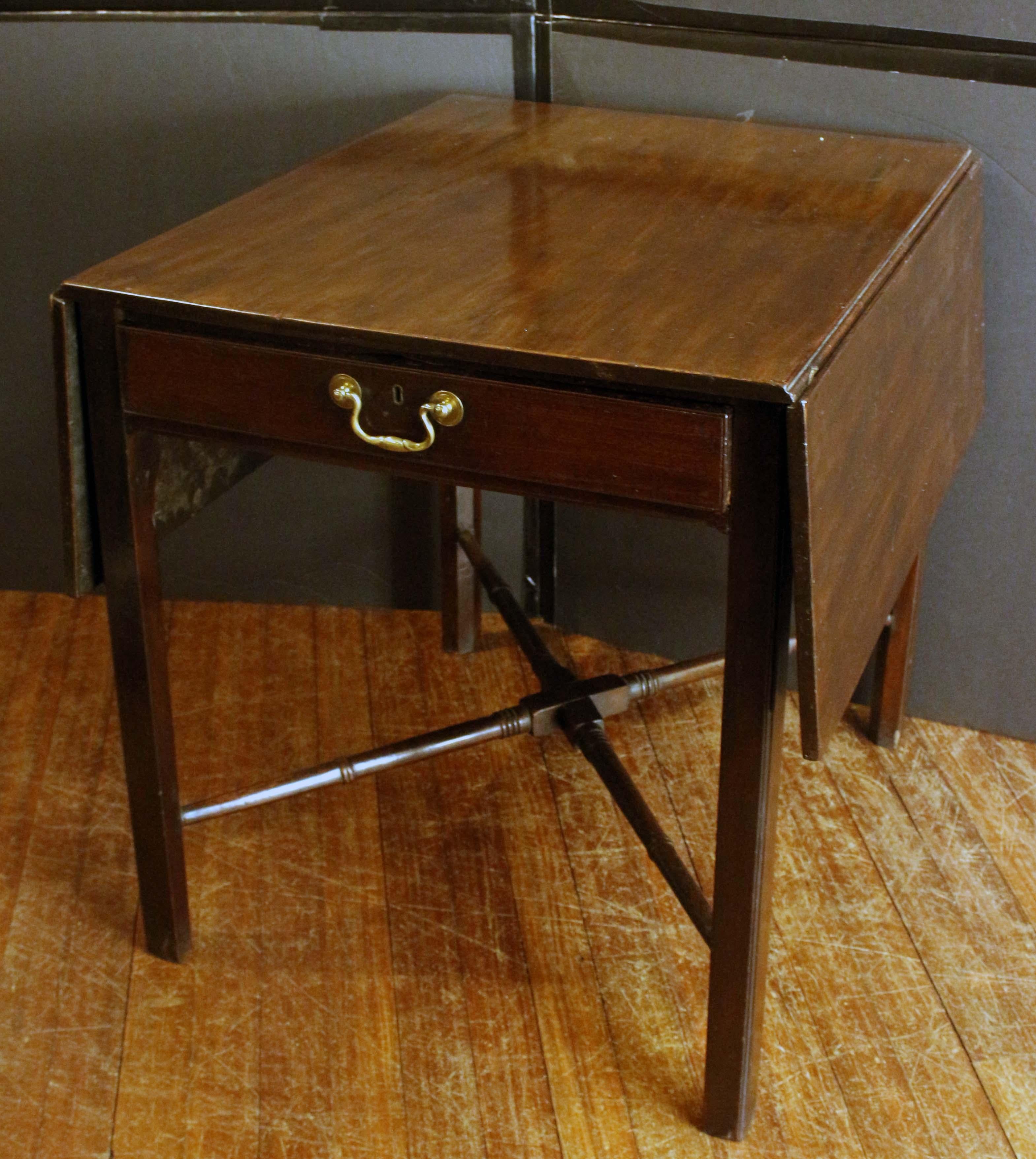 Georgian period cross-stretchered pembroke table. English. Mahogany. Well turned stretchers. Single drawer with shaped bail & rosette pull. One side lifts slightly when the leaf is down. Old scarring to the top. 23 1/2