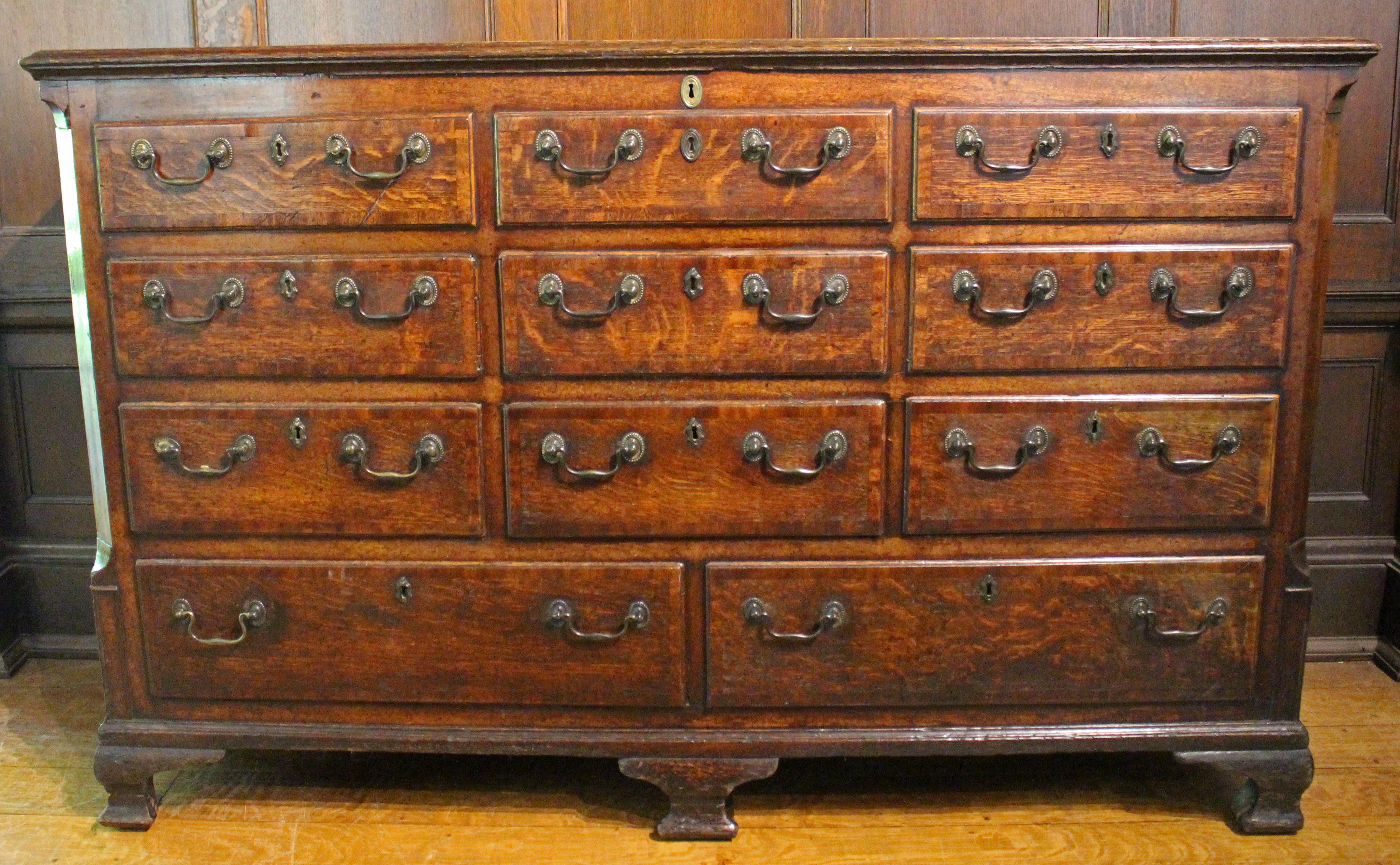 Lancashire mule chest, English. Bail & rosette pulls (mostly original, a few handles appropriately replaced over the years). Molded top. Shaped canted corners. A rank of 3 over 3 faux drawers for the lift-top storage, over 3 working drawers, over 2