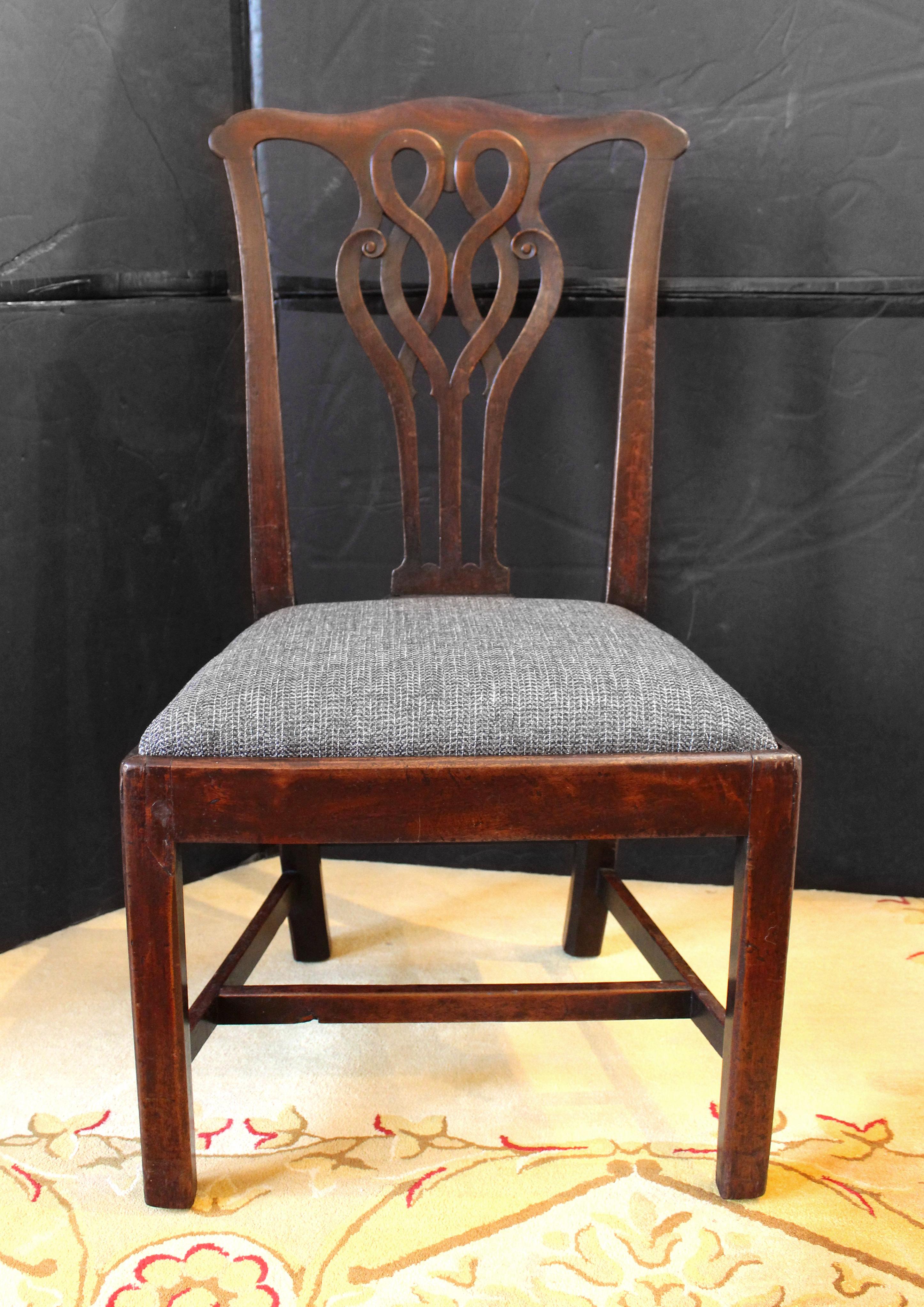 Circa 1760 set of four walnut side chairs, English. George II-III transitional; Chippendale design influence. Remarkable interlaced carved backs exhibit the scrolling of the Rococo transitioning to the Neoclassical. The pronounced 