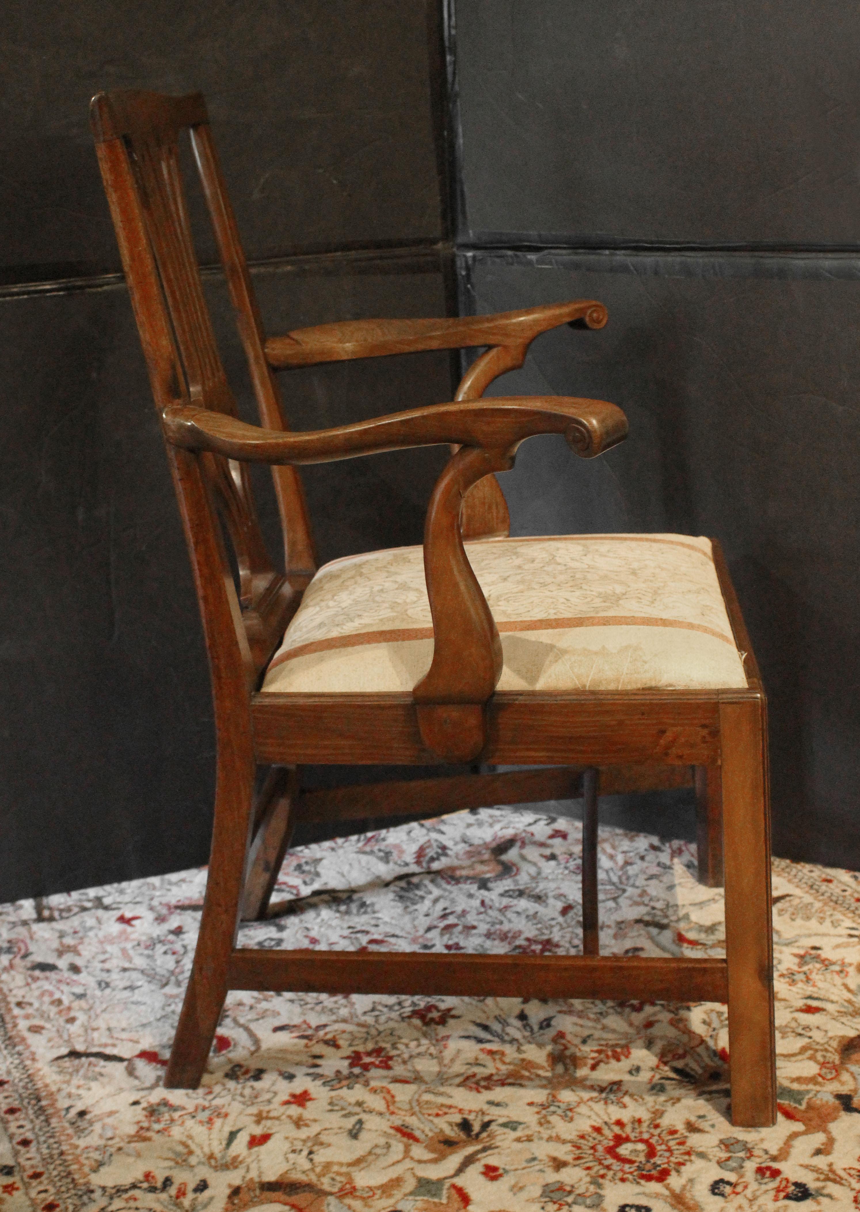 CIRCA 1765-80 Poltrona in noce di Giorgio III, inglese. Un design audace ma semplice, con bracci straordinari con ritorni intagliati a forma di vortice e supporti ben sagomati. La figura del legno è eccellente. Gambe quadrate con bordo in rilievo.