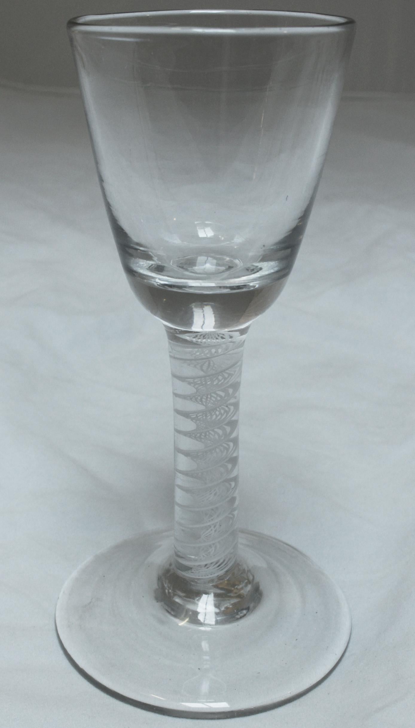 Toastmaster's wine glass, c. 1765, of round pointed funnel form on opaque twist stem & heavy base, English. Note the bottom of the bowl is deceptive. The single wide & multiple thin spiral threads are exceptional.
5 7/8