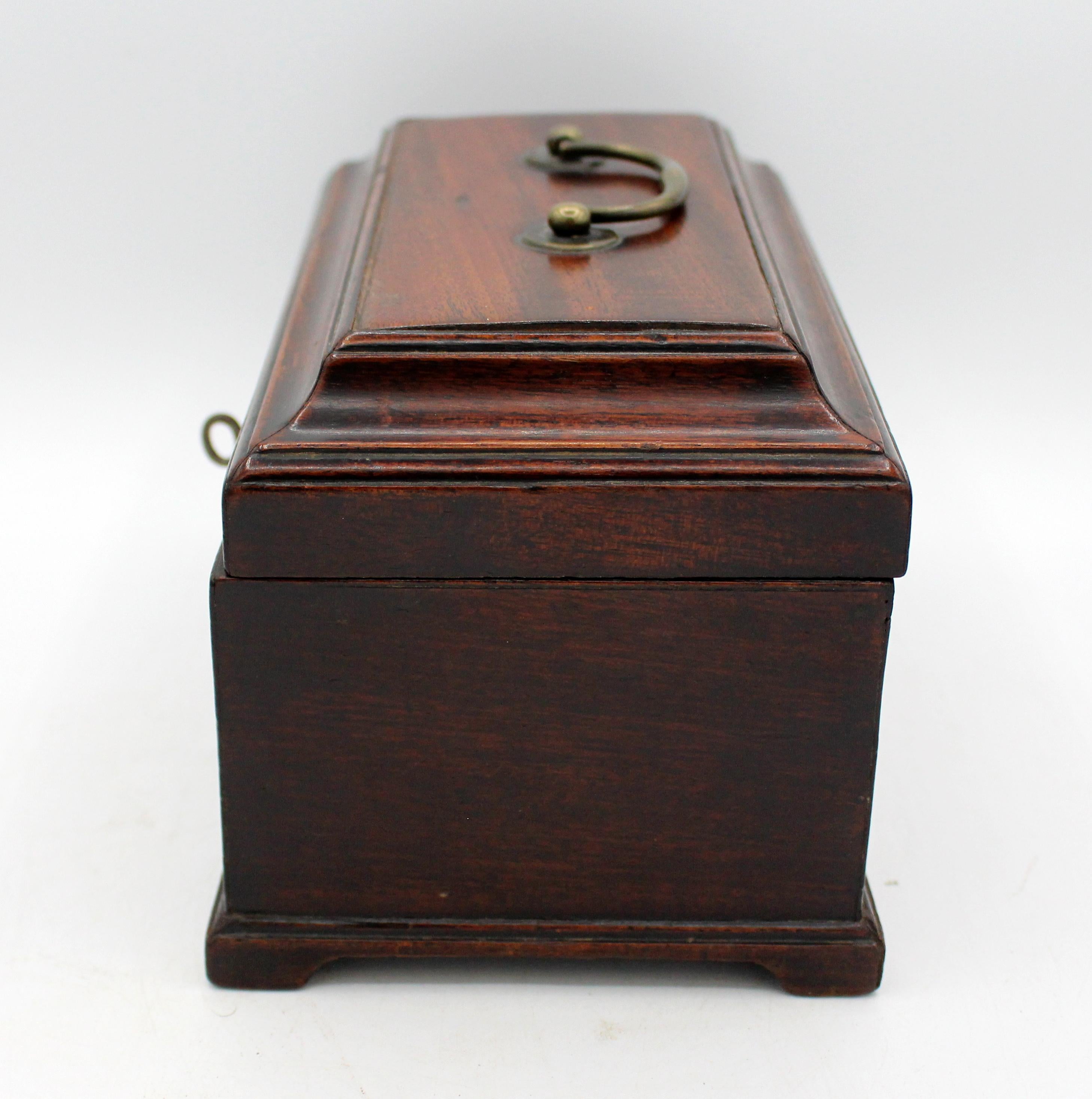 Circa 1765 George III period tea caddy box, English. Small & complete example raised on original bracket feet. Mahogany. Original hardware & lock with key. Contains 2 original tin tea canisters & a hinged, domed top sugar canister. Spoon