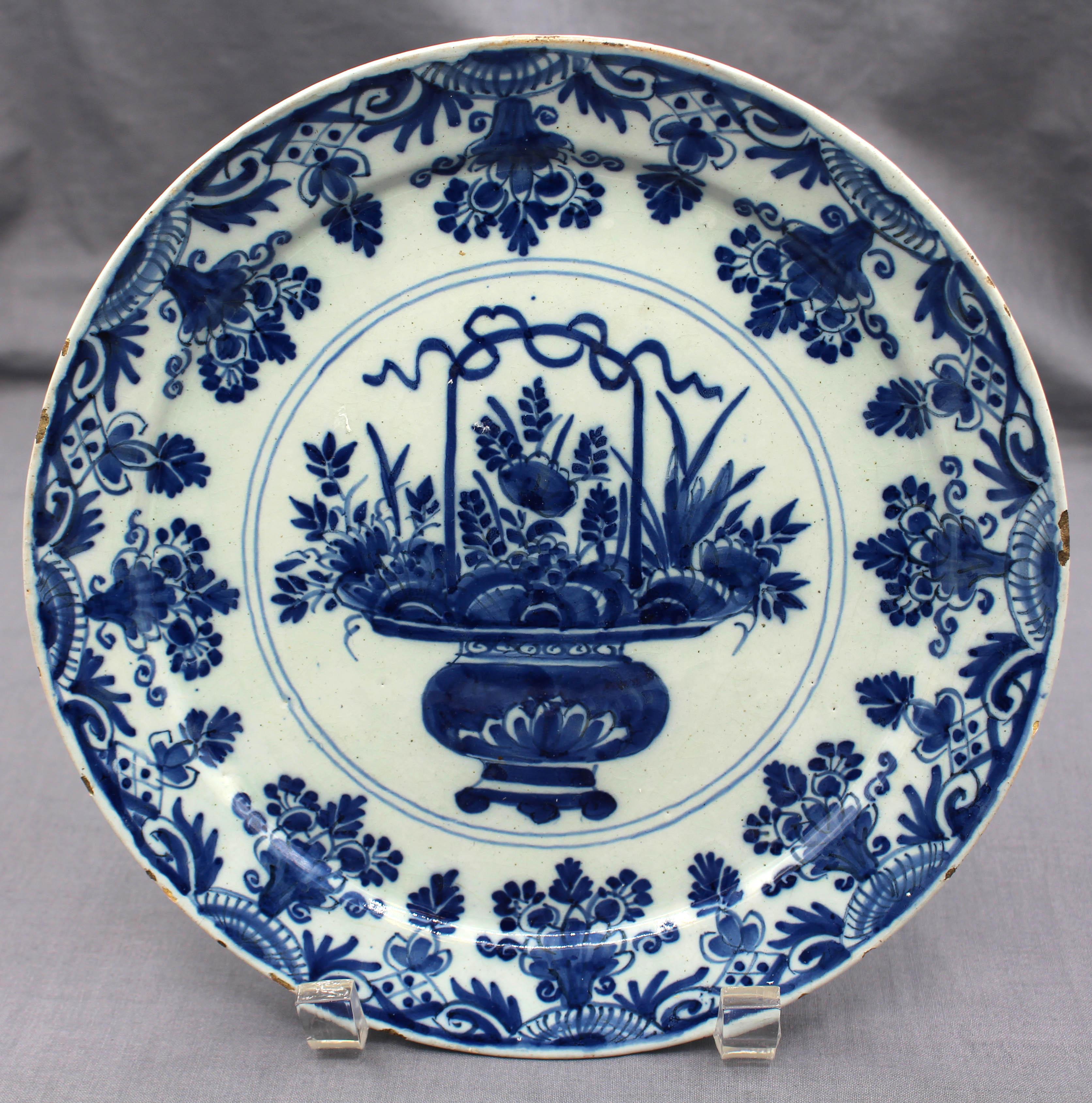 Vers 1770, assiette en bleu et blanc de Delft. Vase central à anse et pied débordant de fleurs, entouré d'une alternance de vases floraux répétitifs et de motifs naturalistes. Fruits correspondant au matériau, à l'âge et à l'utilisation.
8.75
