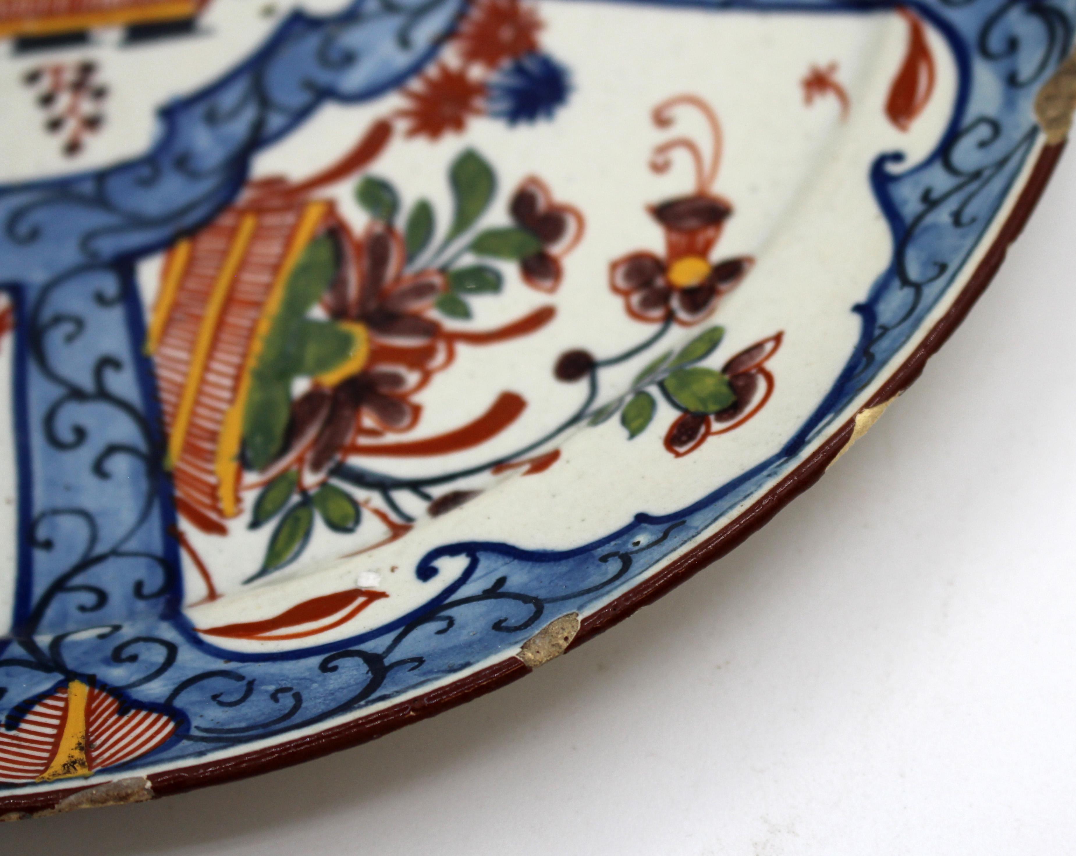 Circa 1770 Delft polychrome plate. Very well decorated with central shaped medallion of a basket of flowers surrounded by 5 shaped panels of flowers baskets. Maker's mark en verso. 4.5