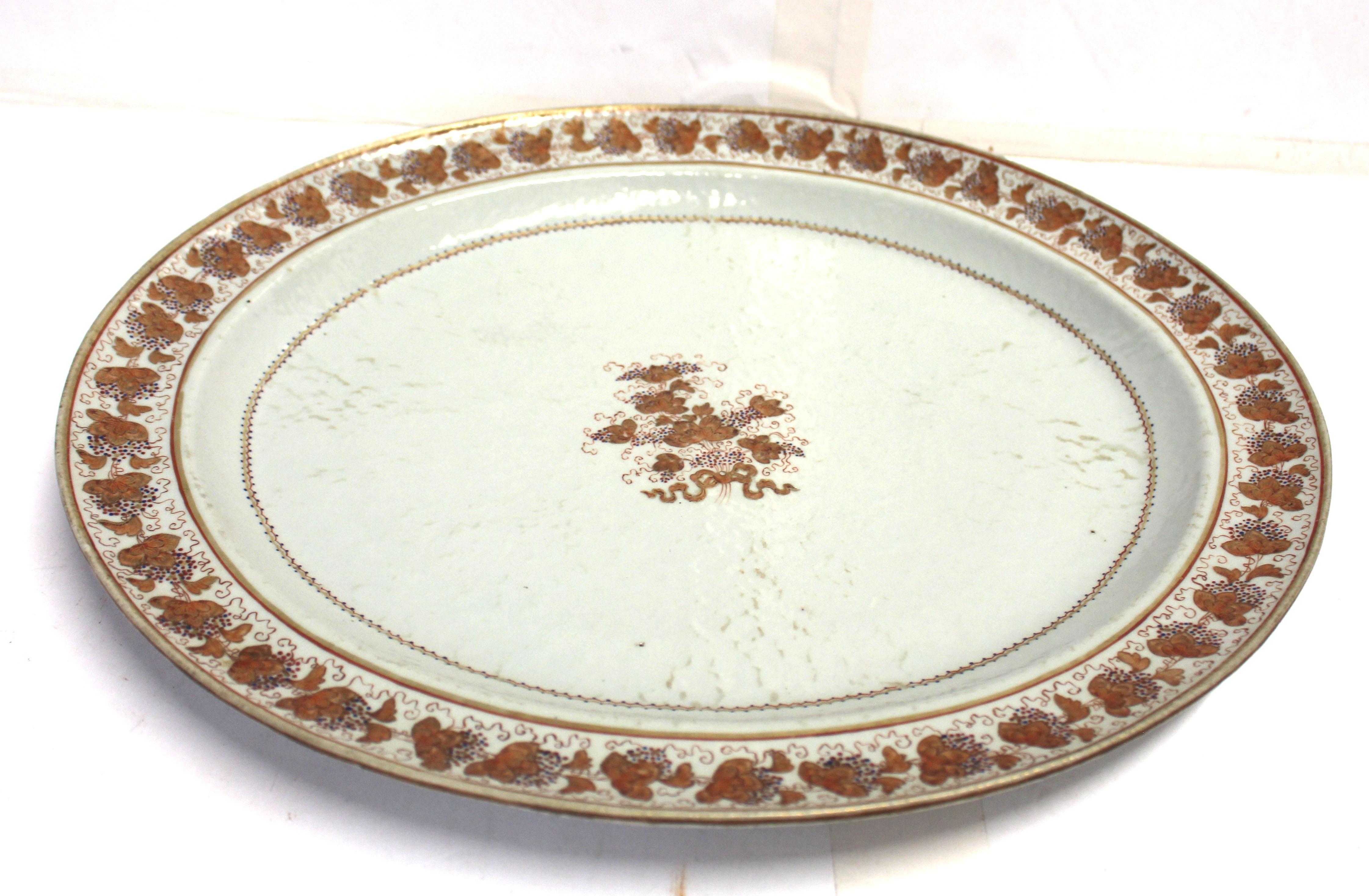 Circa 1780-1810 Fuente de porcelana china de exportación. El centro y el borde que lo rodea están decorados con flores doradas de color sepia con enredaderas de rosa de familia y flores punteadas de color rosa y azul. Hecho para el mercado
