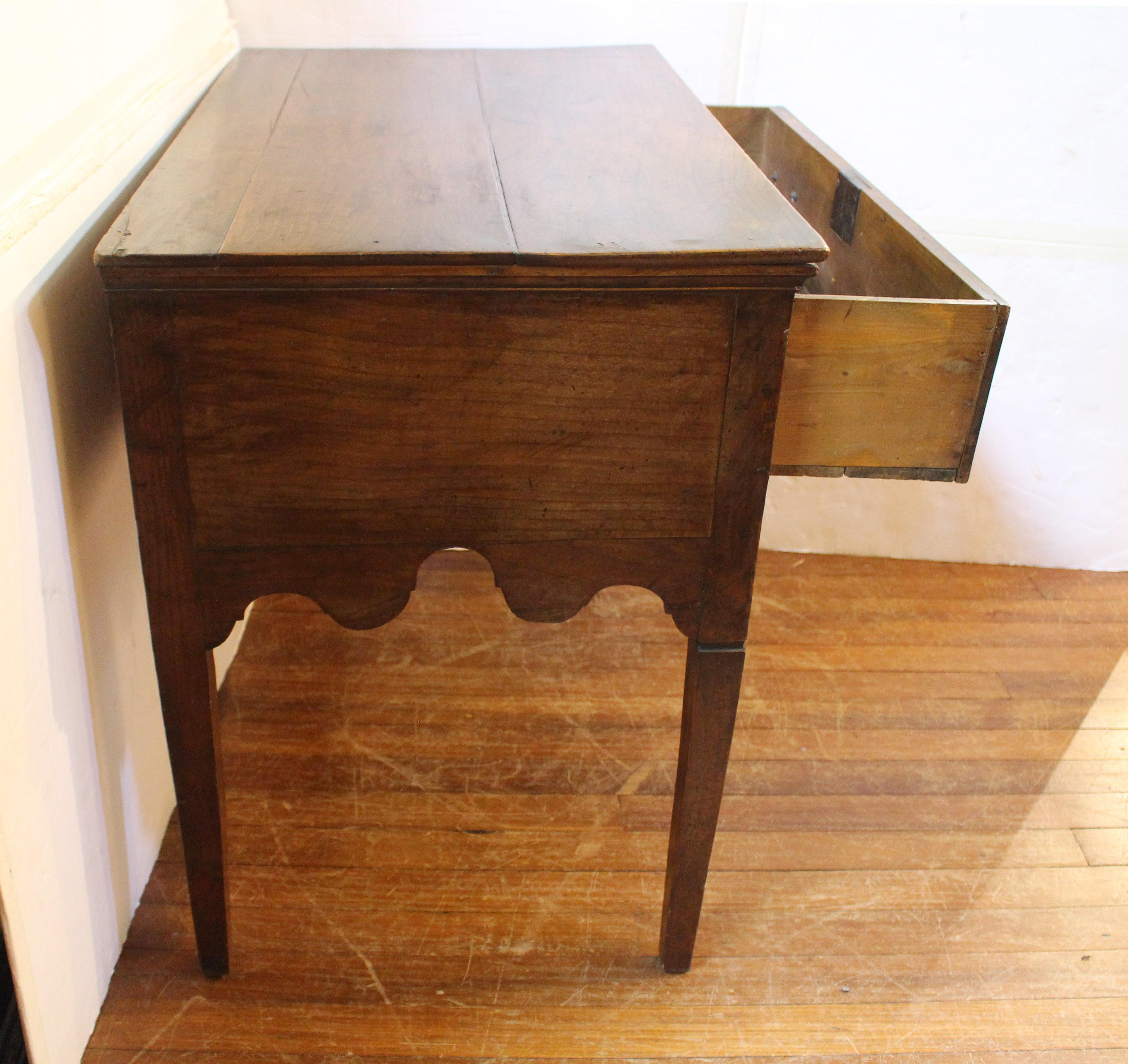 Circa 1780 country Anglo-French lowboy or side table. A charming example of fruitwood with elm & pine secondary wood. Multi-board top. Exceptionally well shaped aprons. Long drawer with brass bail & rosette pulls flanked by reeded accents. Molded