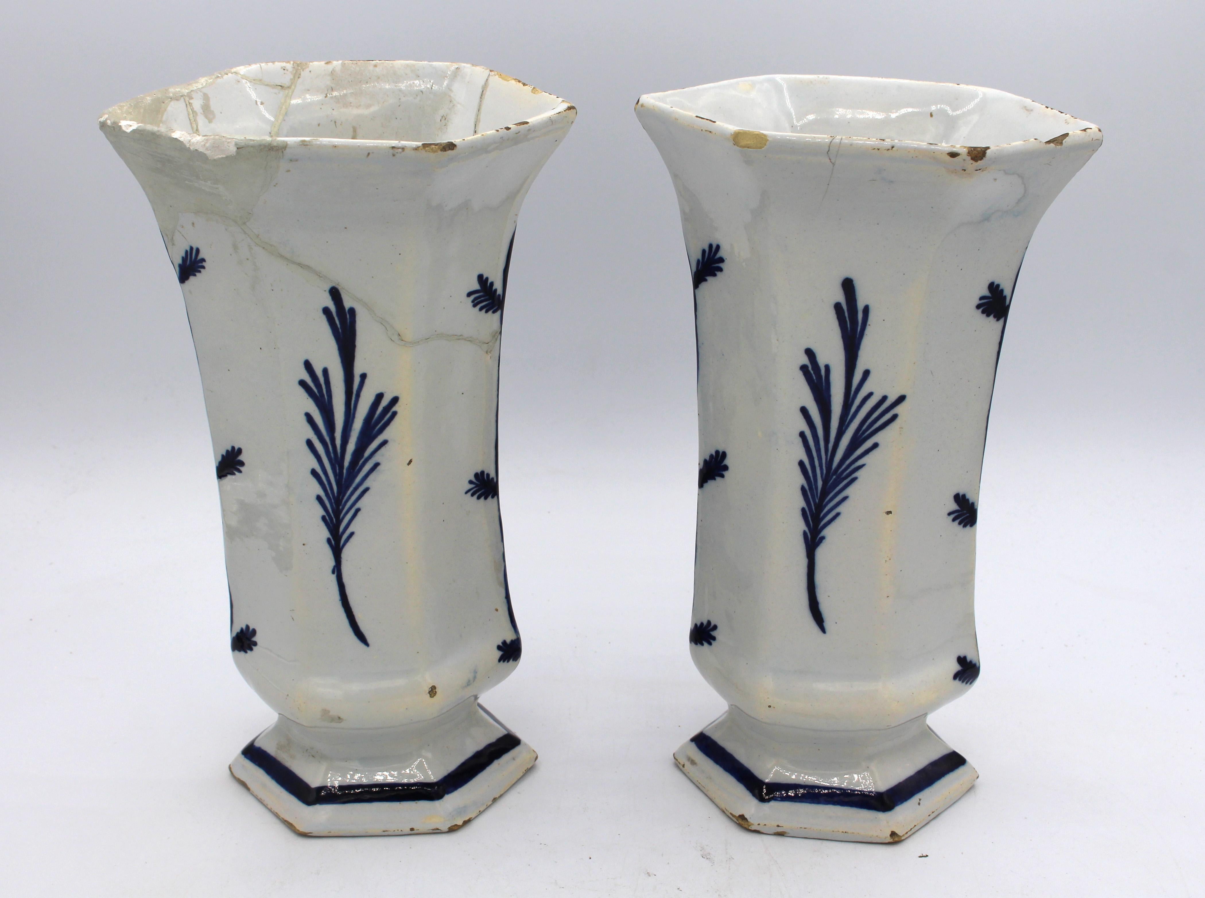 Pareja de vasos blancos y azules de Delft de hacia 1780. Amplia decoración floral y de cartelas de rejas asiáticas. Es probable que formara parte de un conjunto más amplio. Reparaciones tempranas extensas, ahora descoloridas. Fritas de borde. 8,75