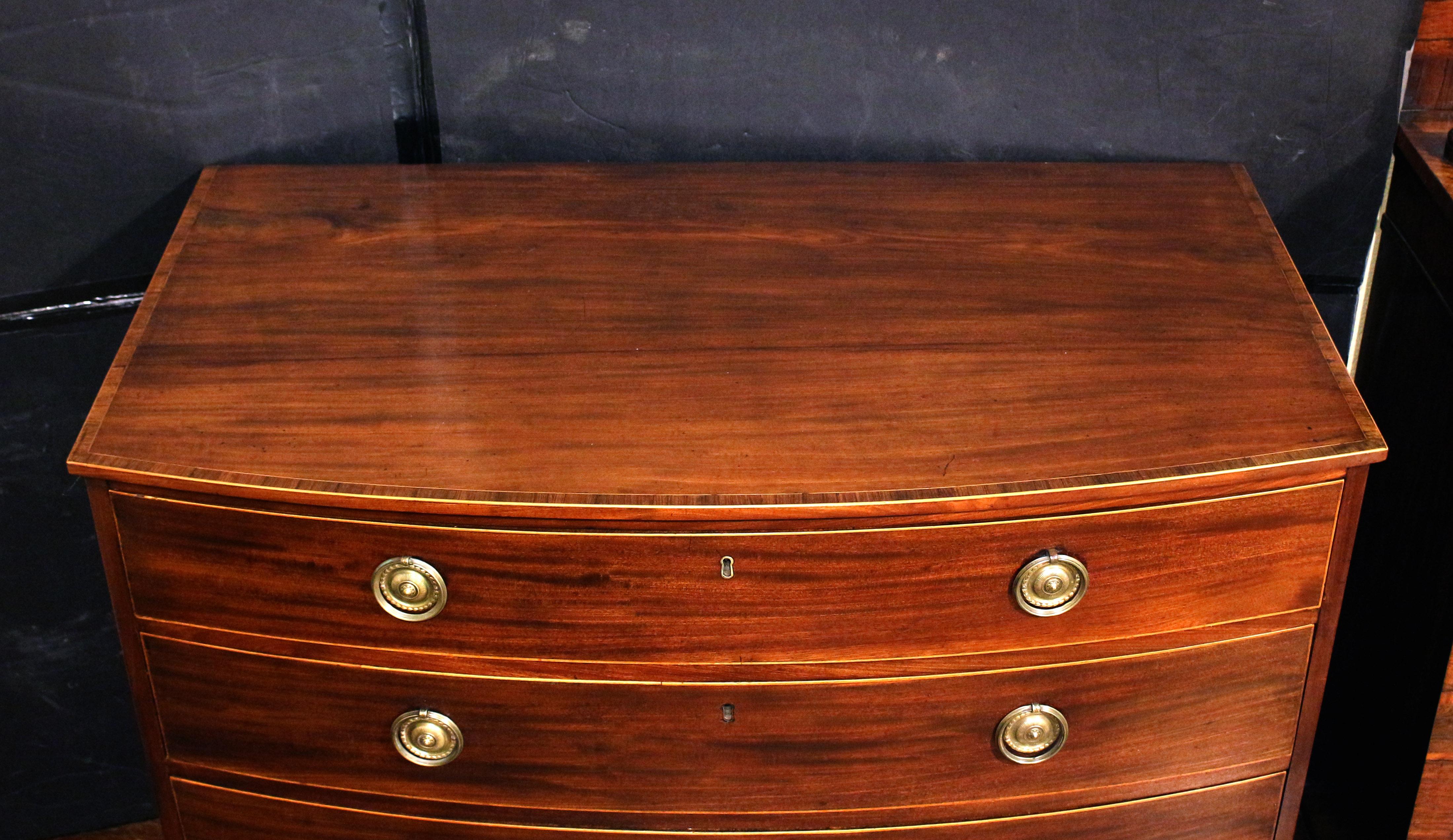 Cassettiera con arco di Giorgio III del 1790 circa, inglese. Quattro cassetti lunghi e graduati. Il grembiule sagomato completa la forma e gli eleganti piedini francesi. I cassetti e il bordo superiore sono delineati da un'incorniciatura in bosso.