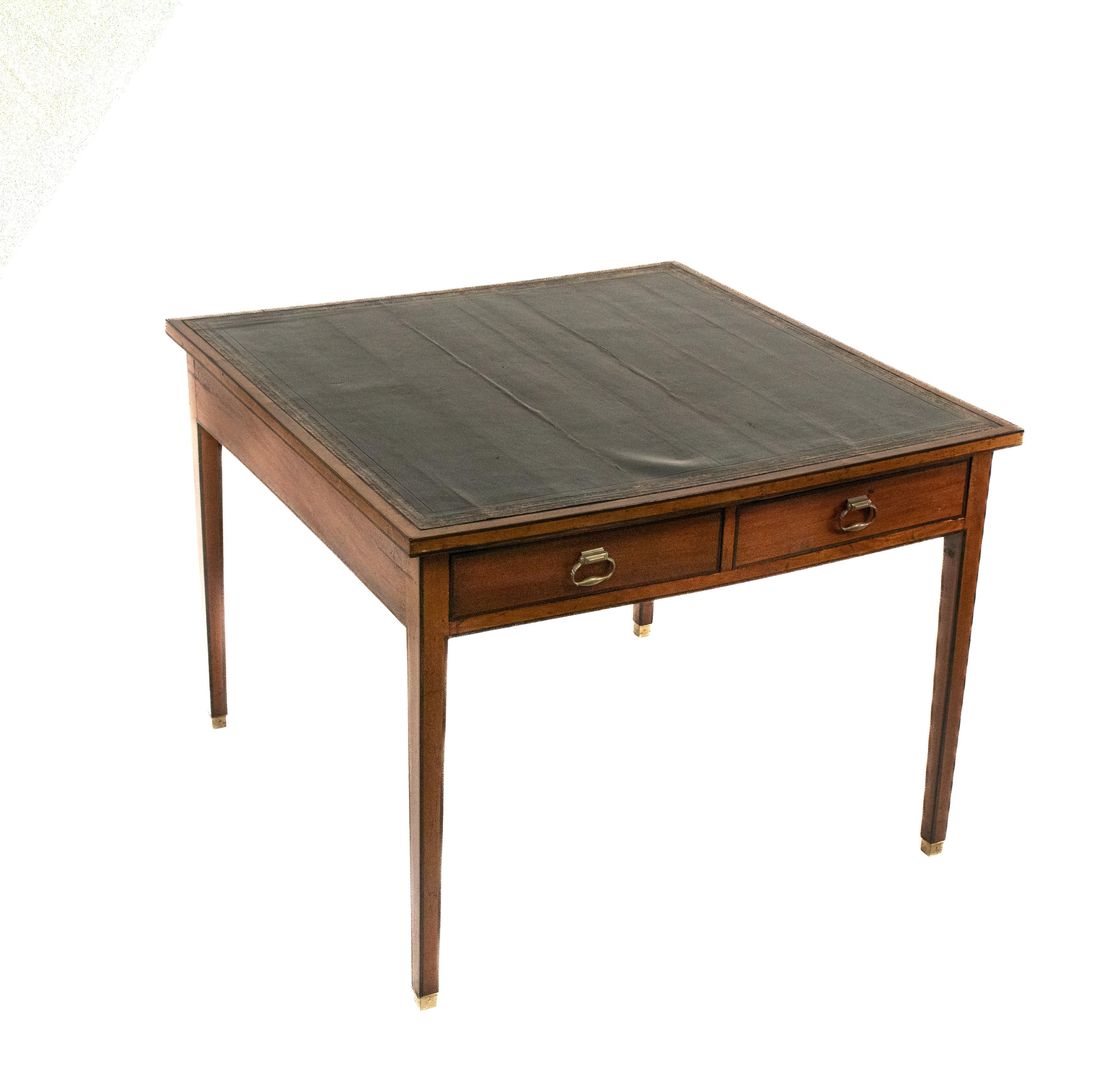 This George III table has gold embossed trim around a beautifully weathered dark green-blue leather tabletop. The square body has been made entirely from mahogany with a mahogany veneer. It has a cross-banded mahogany edge around the leather top.
