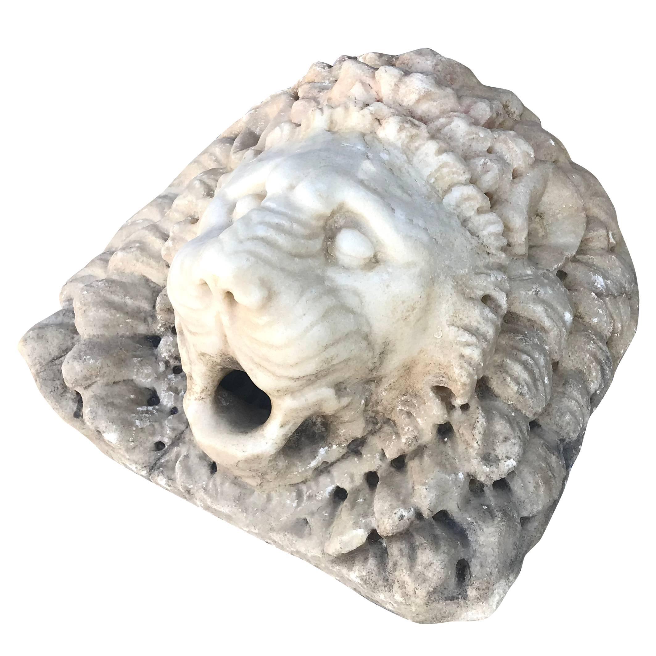 A late Renaissance lion head fragment to use as a fountain head. Entirely hand carved in Carrara marble. Wear consistent with age and use. Circa 17th Century, Italy.