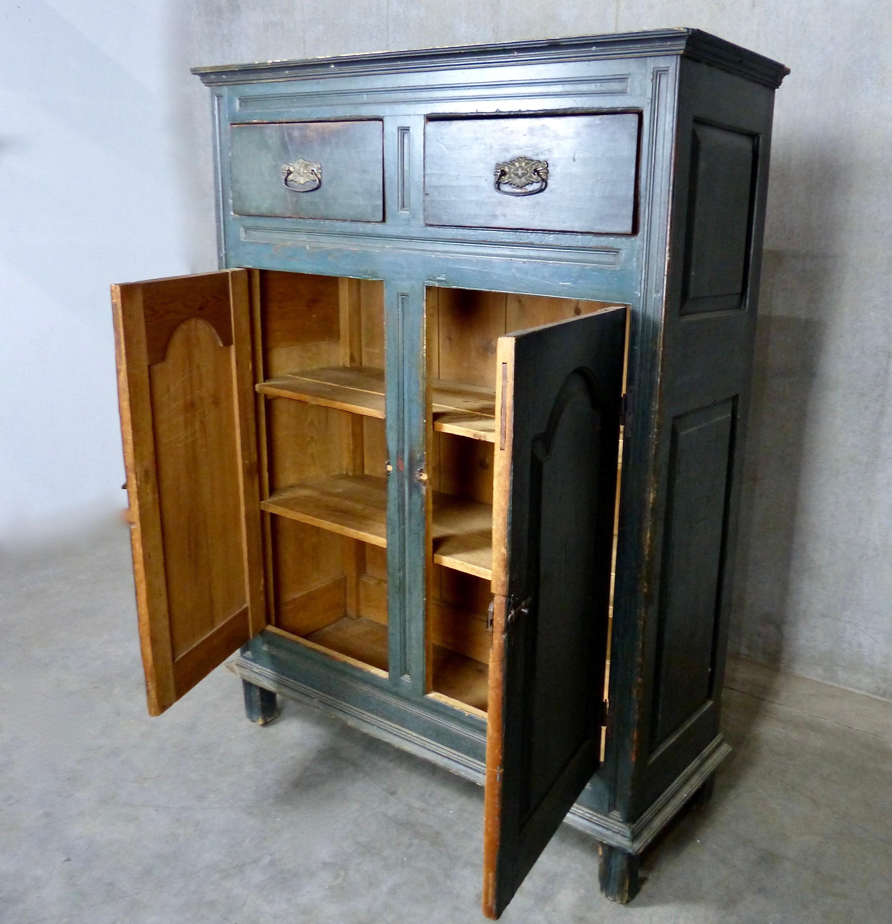 A rare and early, teal blue Quebec painted pine cabinet from circa 1800-1810. Two deep upper drawers along with three shelves behind doors on the lower portion. Original surface paint and original hardware. Handcrafted wood is nicely detailed