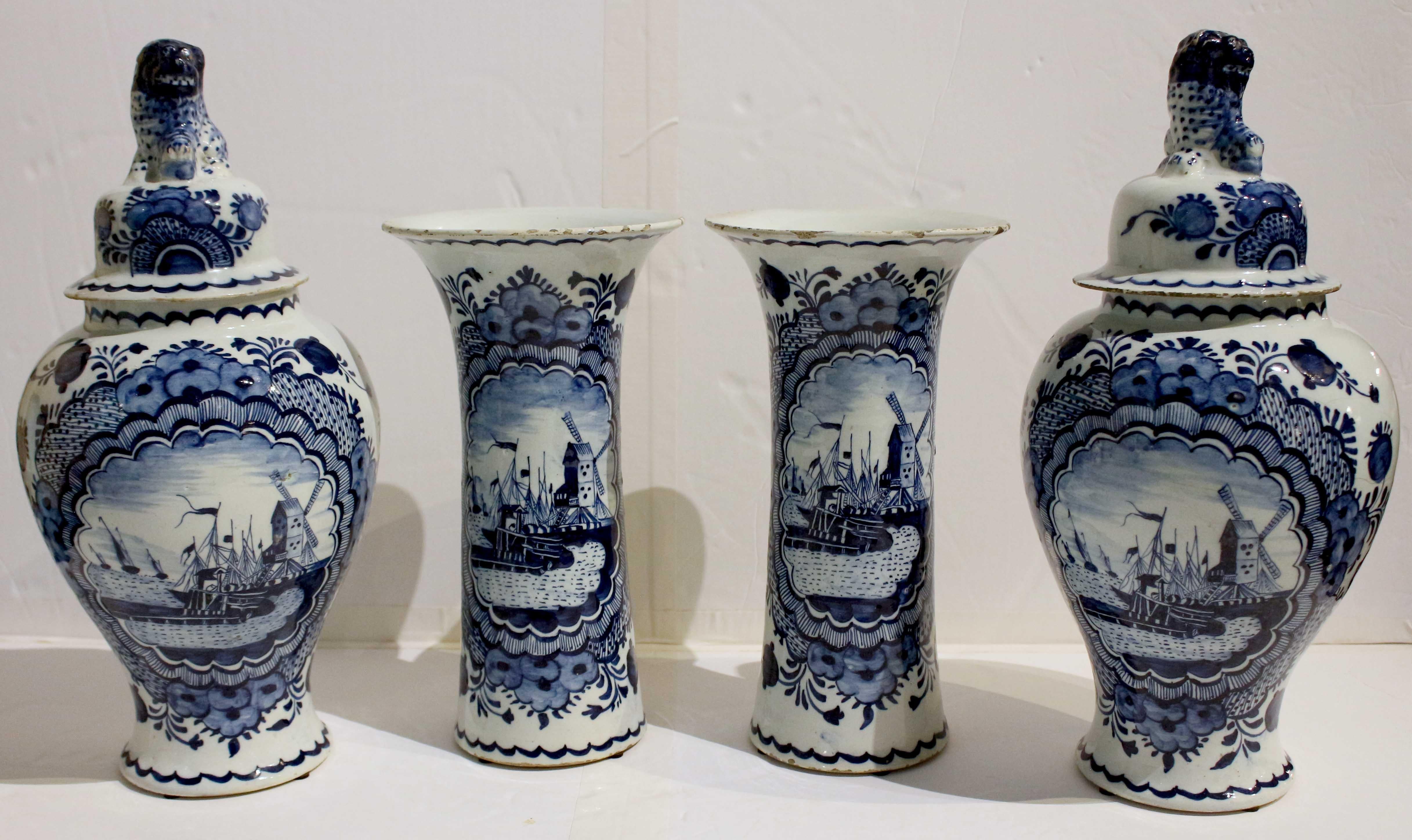 Circa 1800 Delft 4-piece blue & white garniture set. Comprised of 2 covered jars & 2 beaker vases. Each with central medallion scene of a windmill & ships coming to harbor, reversing to floral tendrils. The jars with foo dog finials. Frits typical